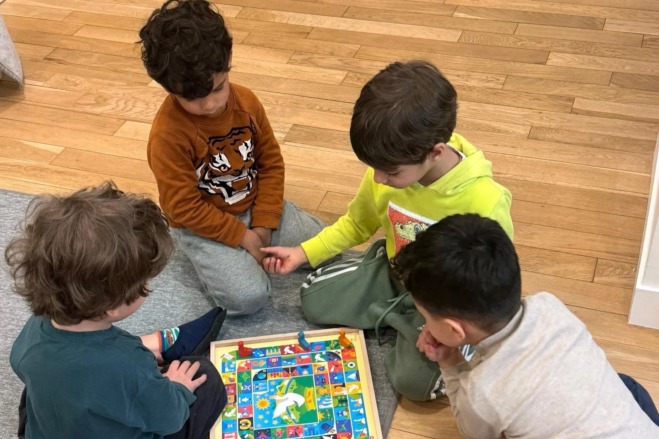 Enfants dans une classe Montessori bilingue, explorant librement le matériel pédagogique sous la supervision d’éducateurs.
