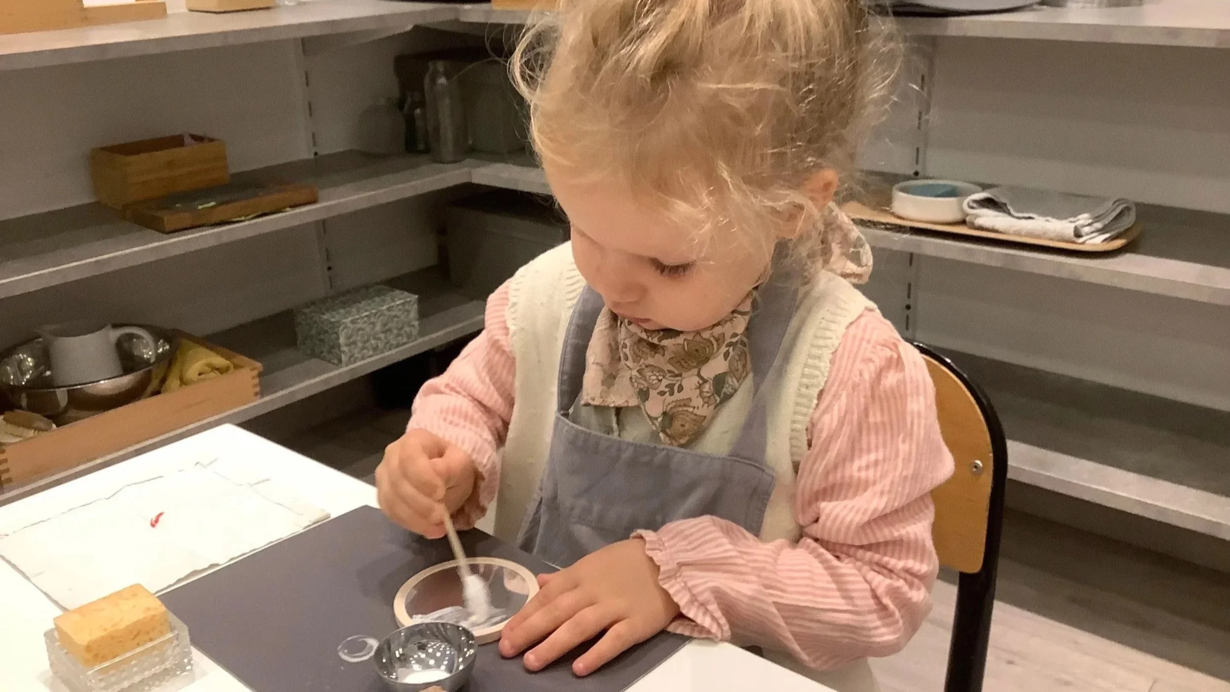 Enfant de 2 ans en activité de vie pratique dans une école Montessori à Paris, alternative à la crèche dès 2 ans.