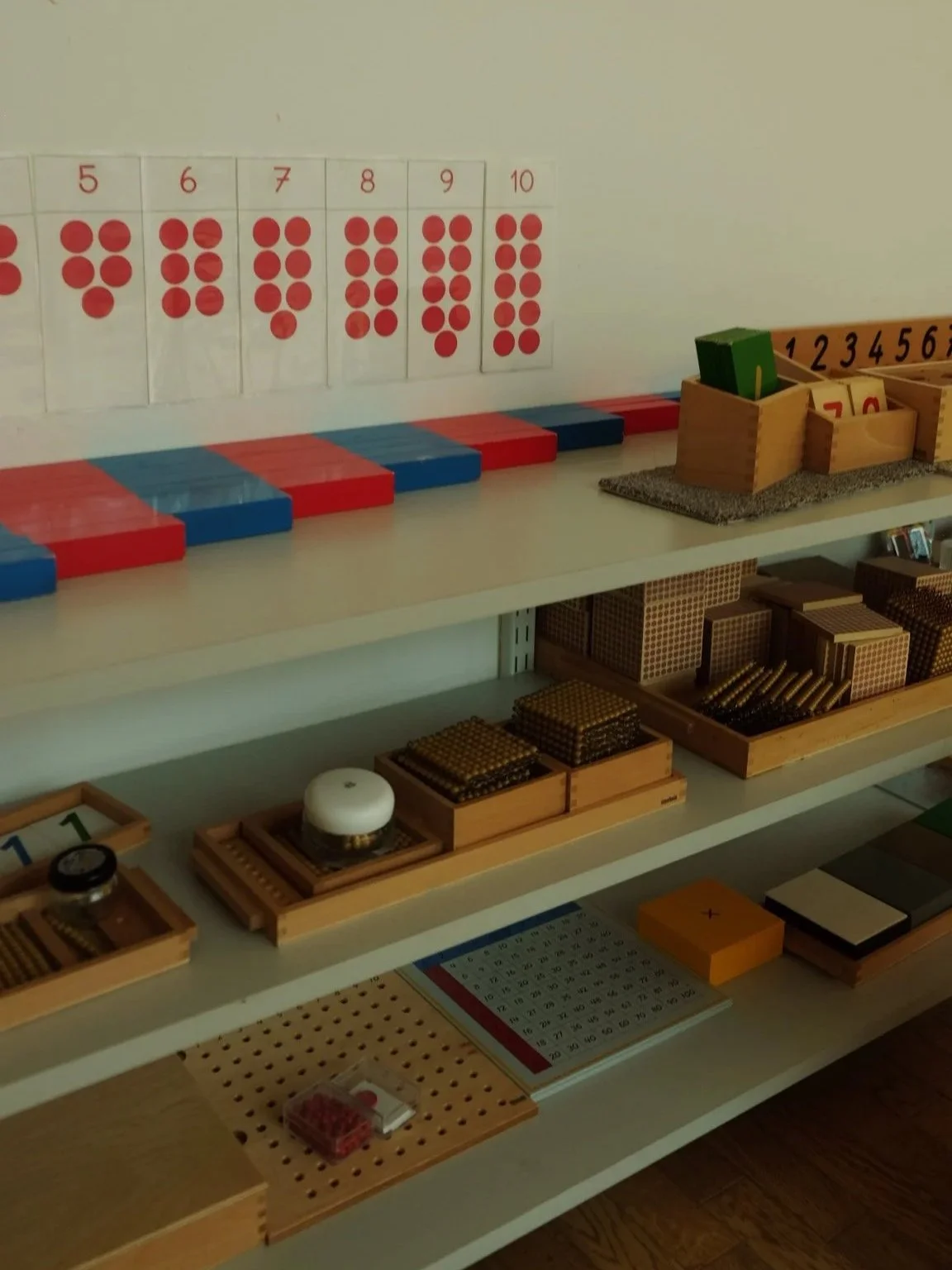 Enfant manipulant des perles et barres numériques Montessori pour apprendre les mathématiques dans nos écoles Montessori Internationales