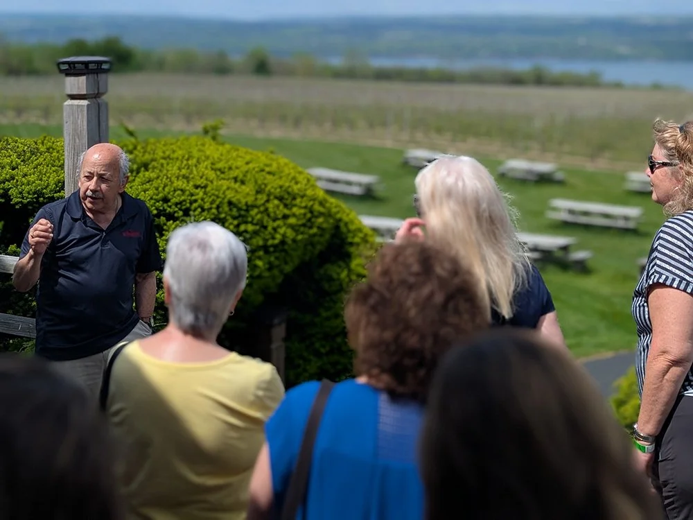 Group enjoying a guided winery experience overlooking the Finger Lakes