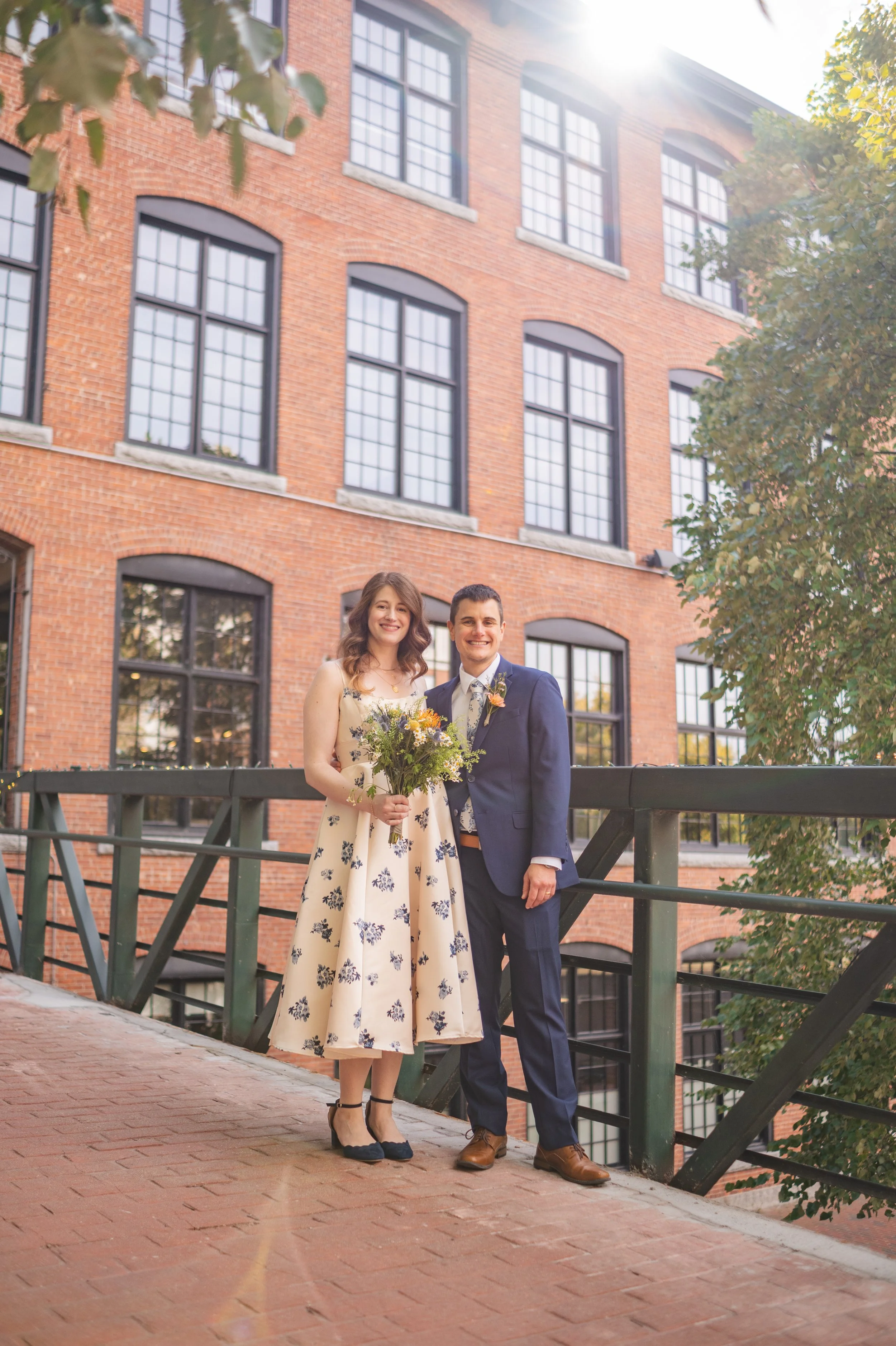 A couple standing in front of a brick building