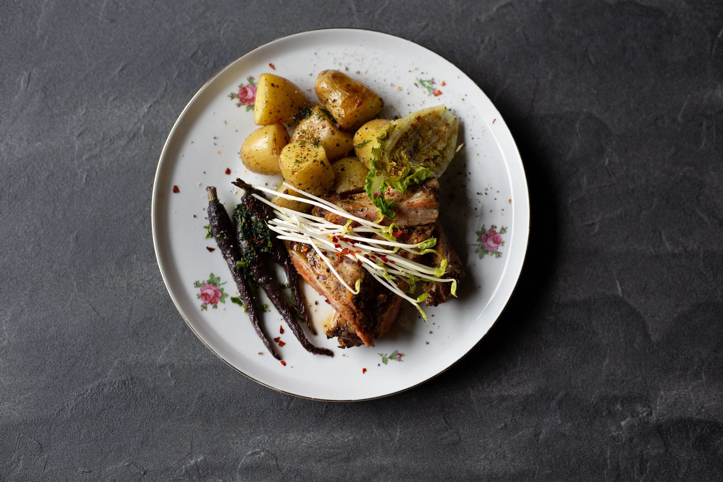 Bord met vis en groenten
Verfijnd cateringgerecht met gegrilde vis, geroosterde aardappelen en verse groenten.