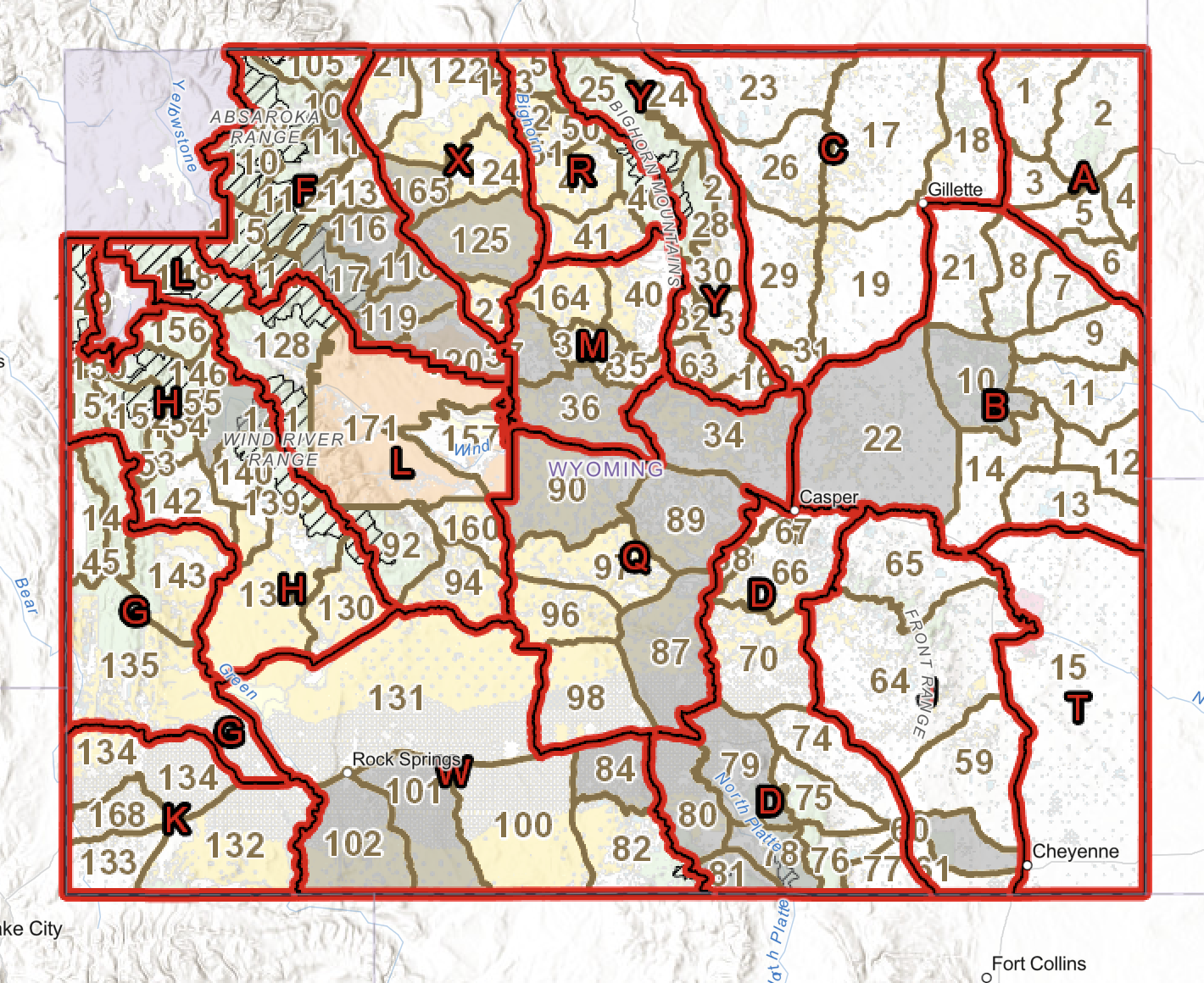 Map of Wyoming with marked regions labeled A through Z, covered with red borders, showing county numbers and names of major cities like Casper, Cheyenne, and Rock Springs, along with mountain ranges, rivers, and natural features.