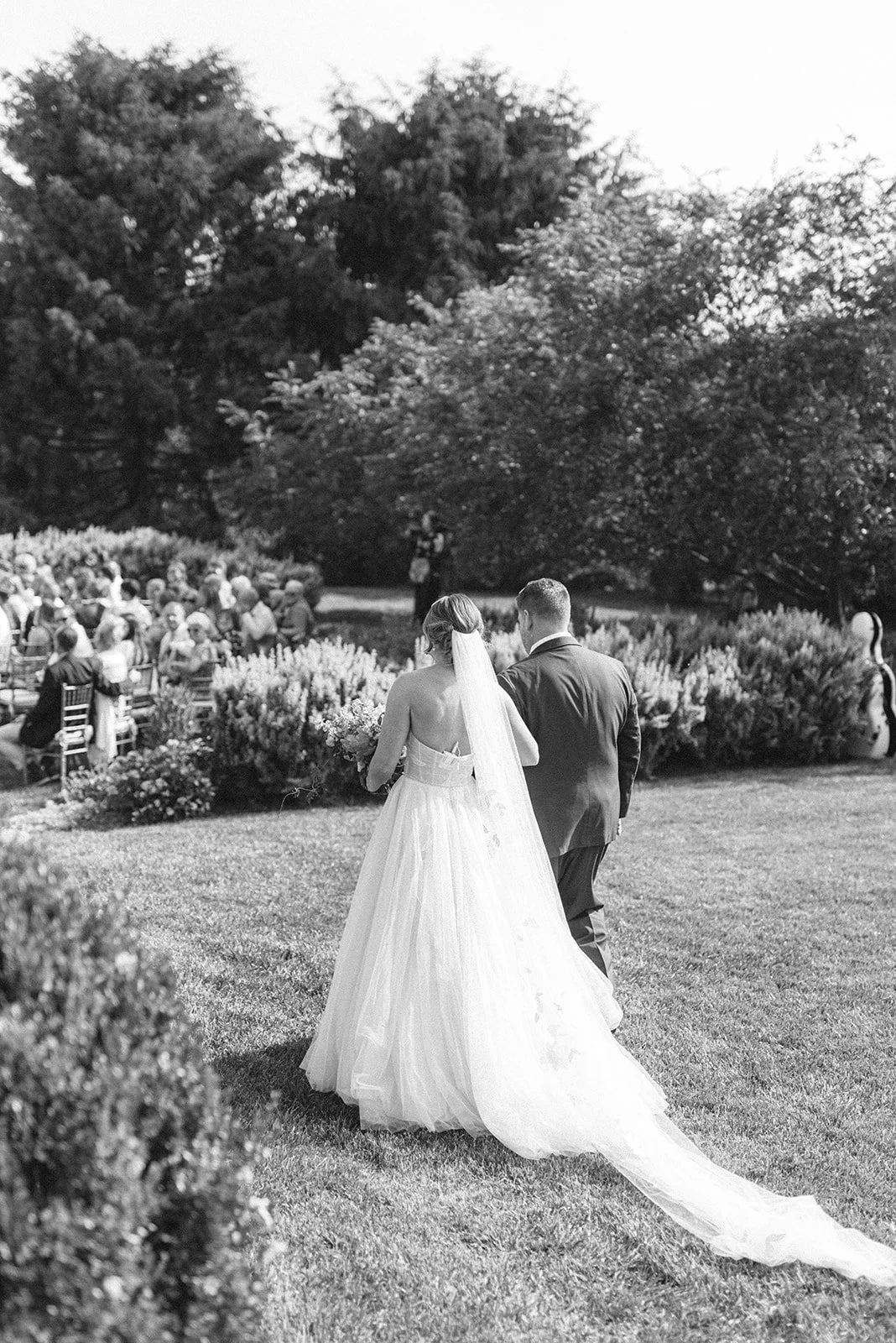 A bride and groom walking away together during an outdoor wedding ceremony in French Park Cincinnati