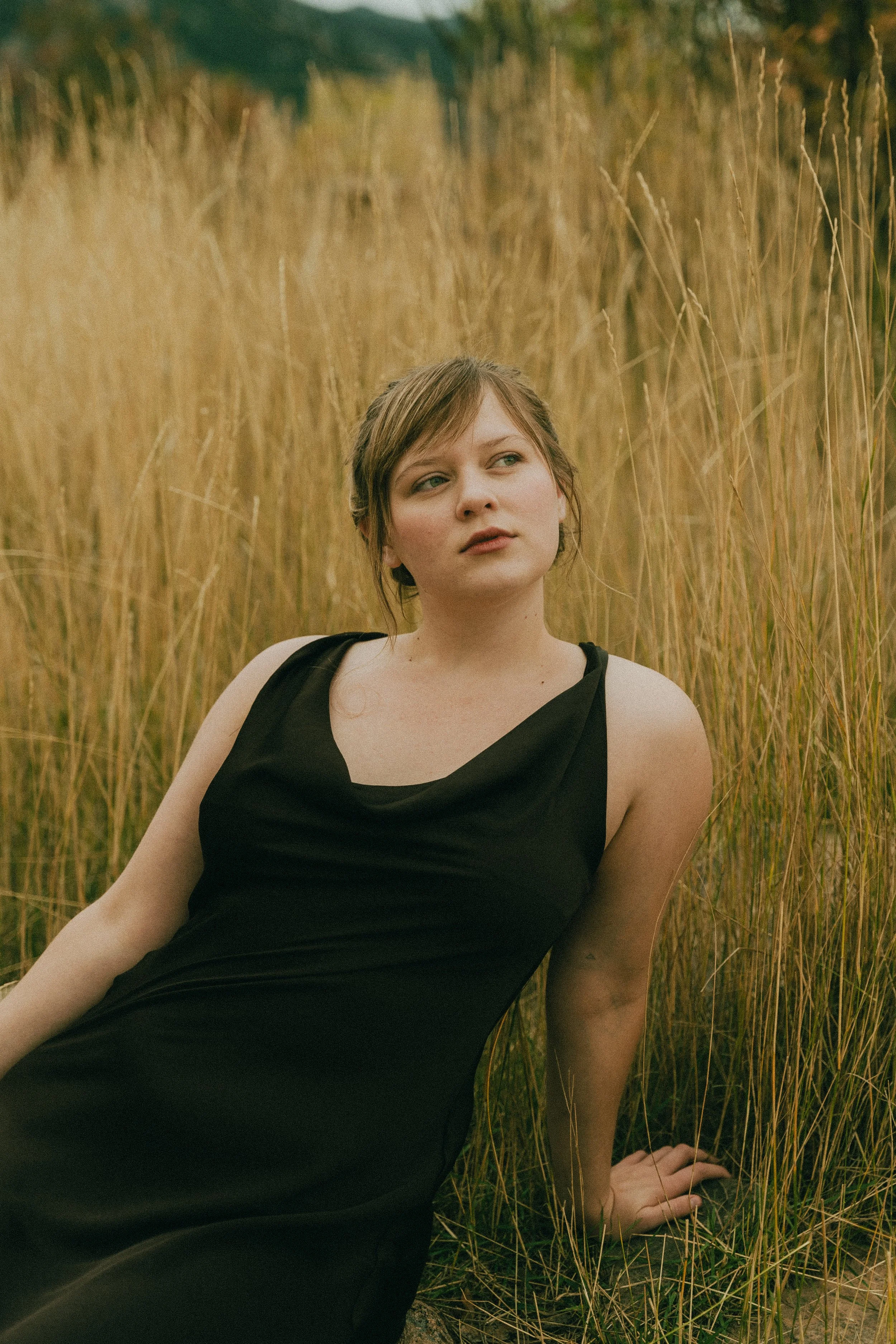  Fall senior portraits at South Mesa Trailhead in Boulder, Colorado featuring girl sitting in golden field.   
