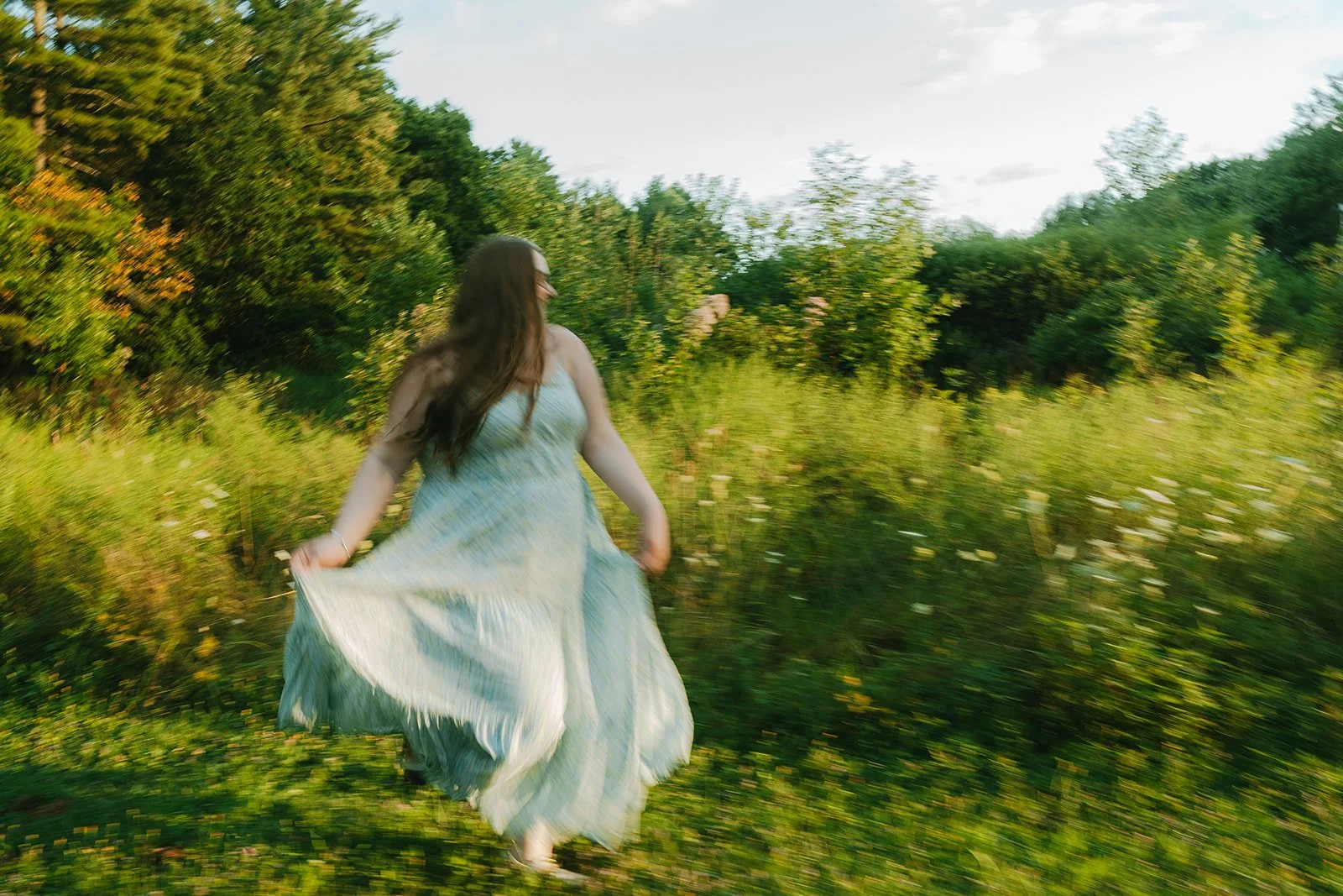 senior girl frolicking through meadow for senior photos in boulder, colorado