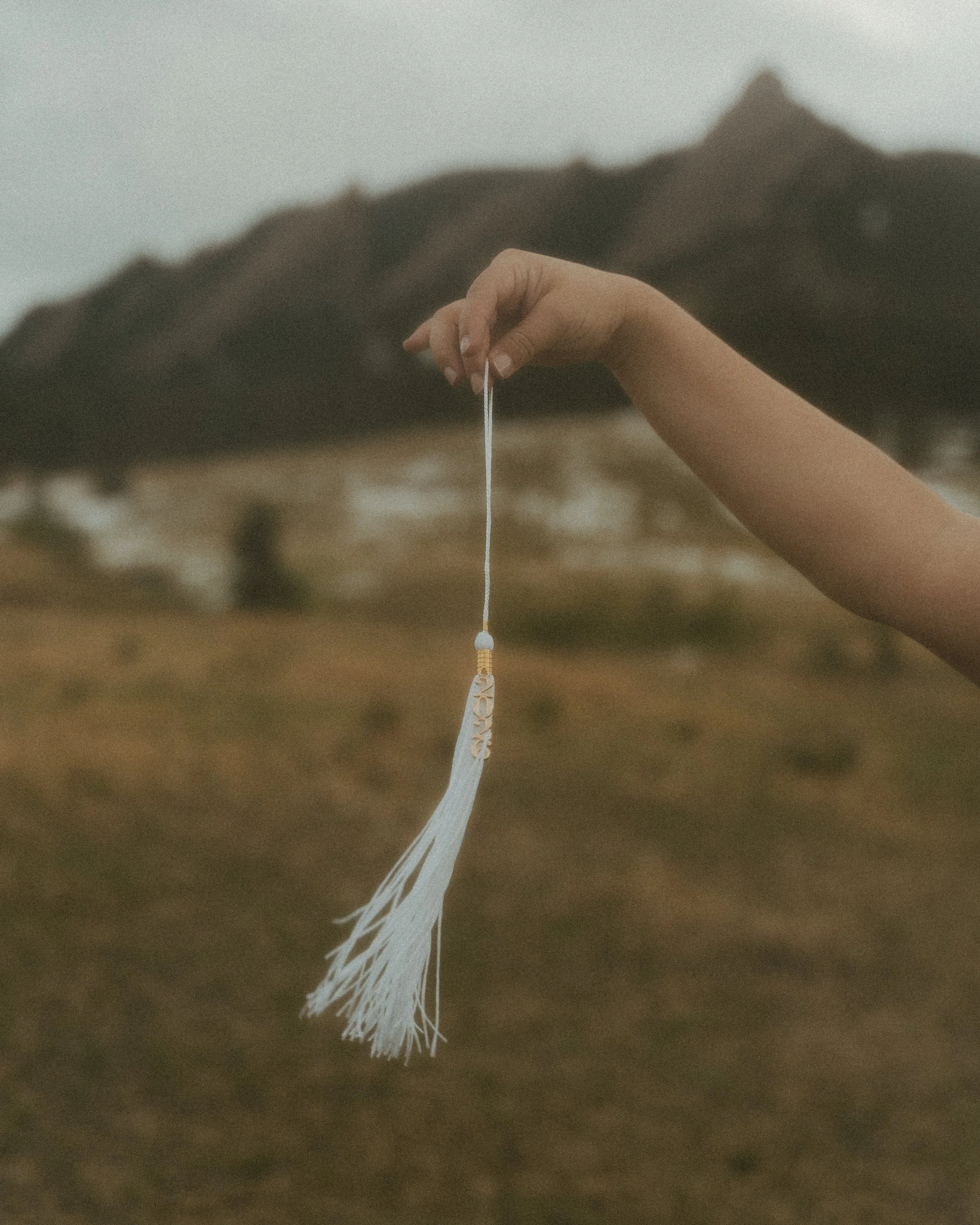 senior graduate holding their 2026 cap string during a senior photoshoot in boulder, colorado