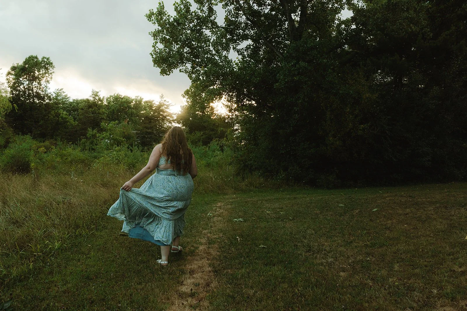 senior girl prancing through a field for senior photos in boulder, colorado