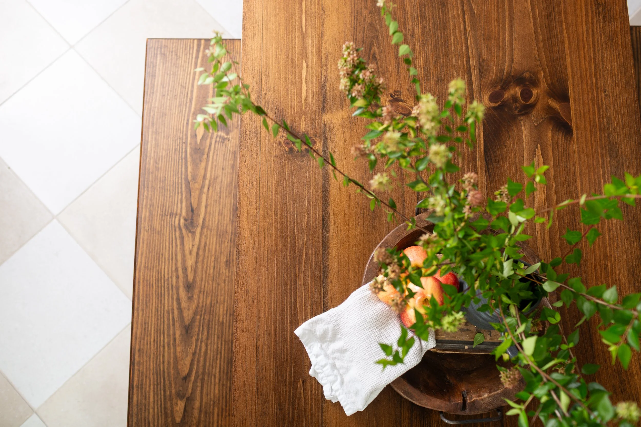 Custom wood table styled with fresh greenery and natural textures in a luxury home designed by MASH Habitat Interiors.