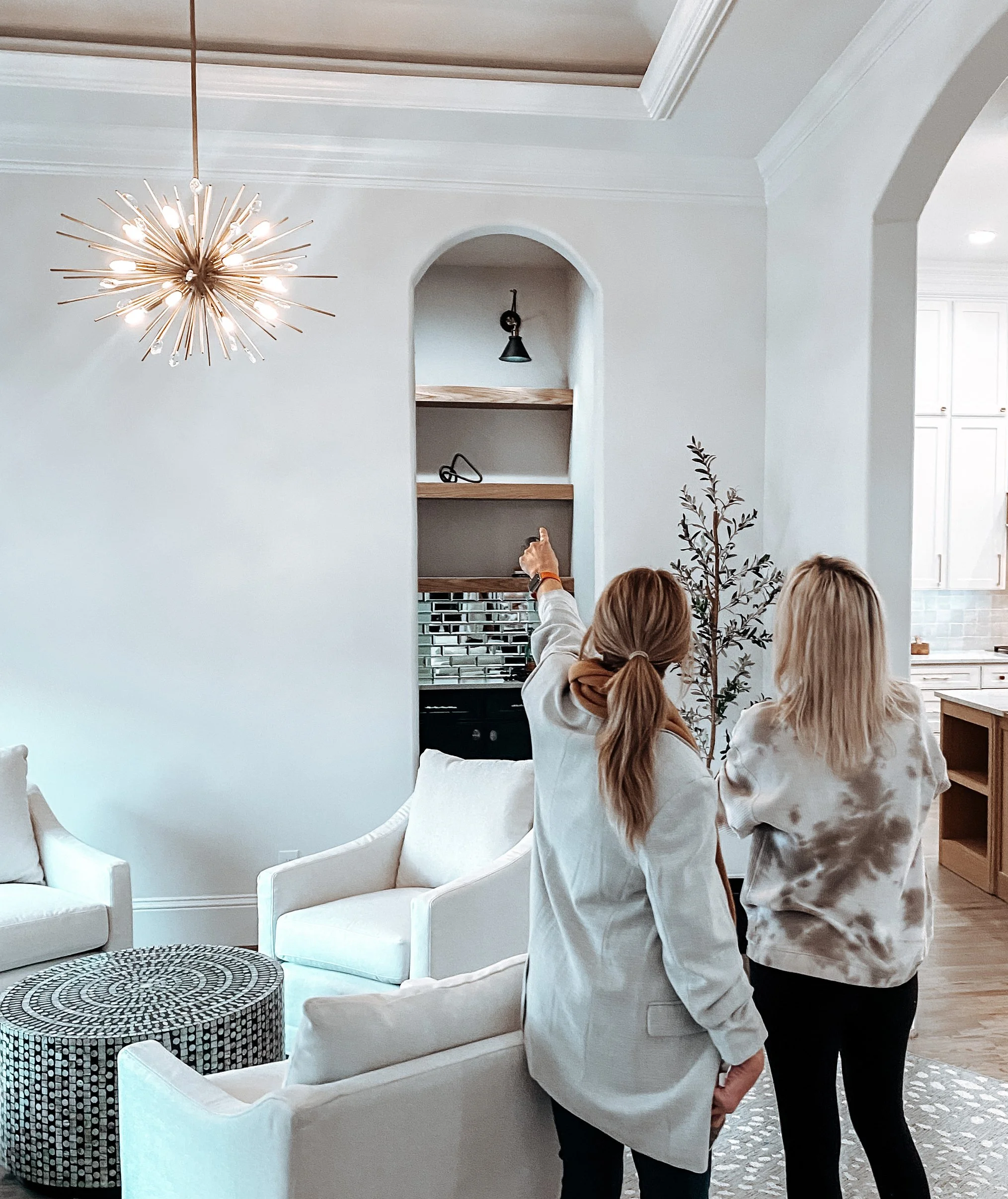 Interior designer Melanie Rosenburg of MASH Habitat Interiors reviews custom built-in shelving and lighting selections with a client during a home remodeling project in Fort Worth, Texas.