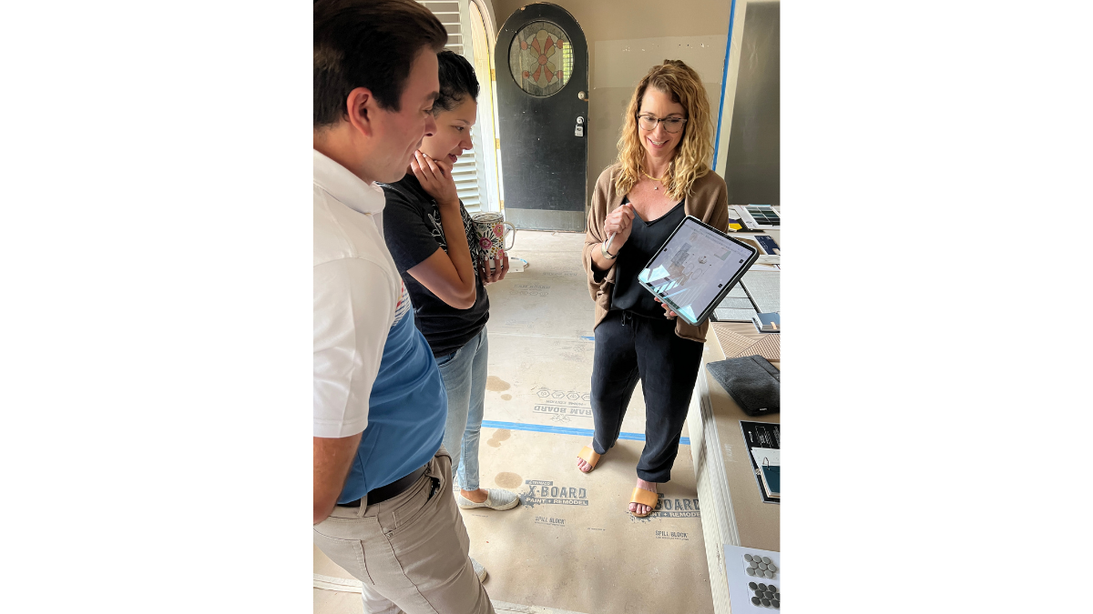 Dallas Interior designer meeting with homeowners during a home remodel consultation to review floor plans, material selections, and design decisions.