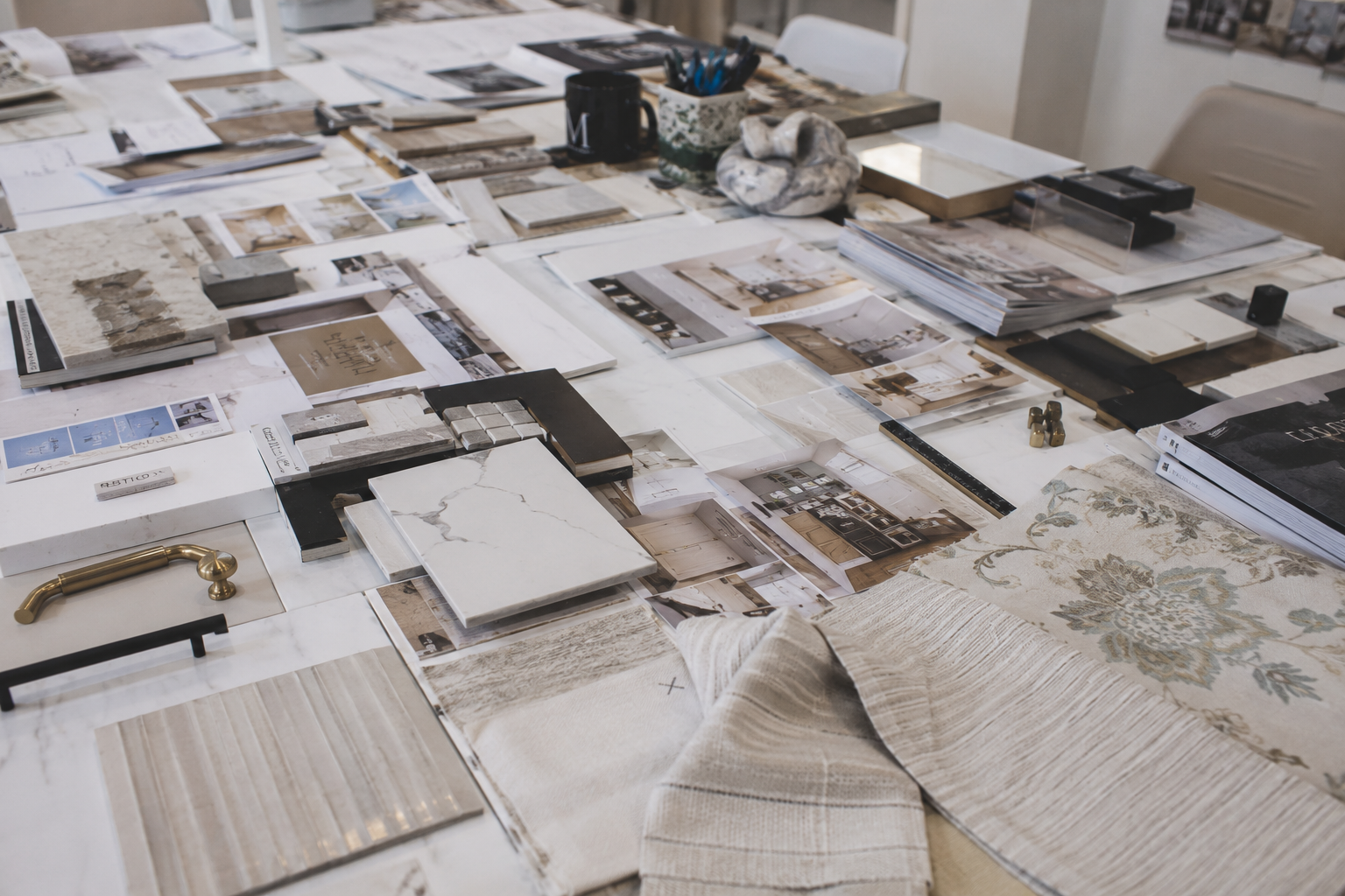 Interior design material selections including stone, tile, fabric, hardware and finish samples arranged for a residential design project.