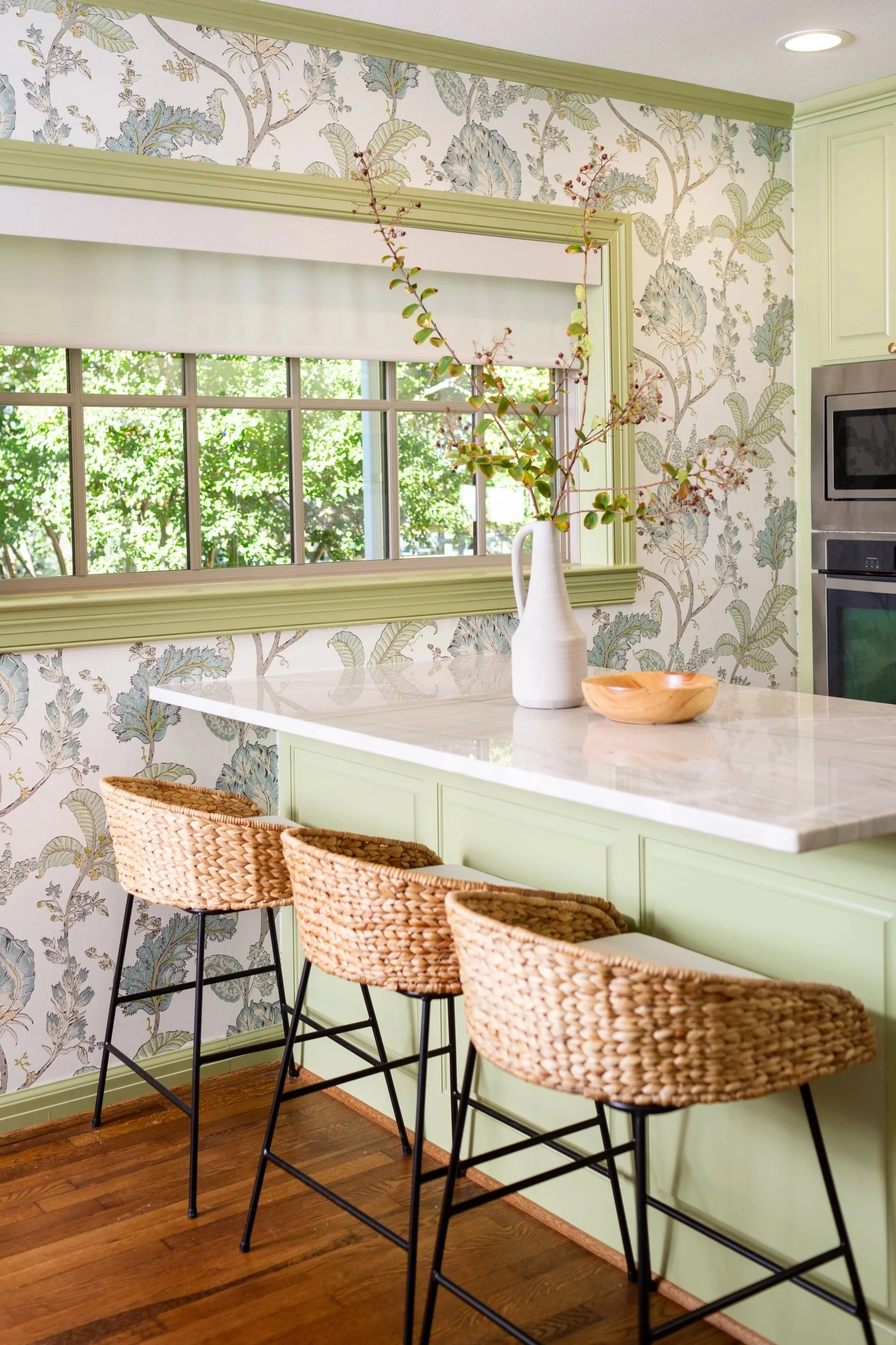 Kitchen featuring botanical wallpaper, painted cabinetry, and coordinated finishes selected by an interior designer to create a cohesive design.