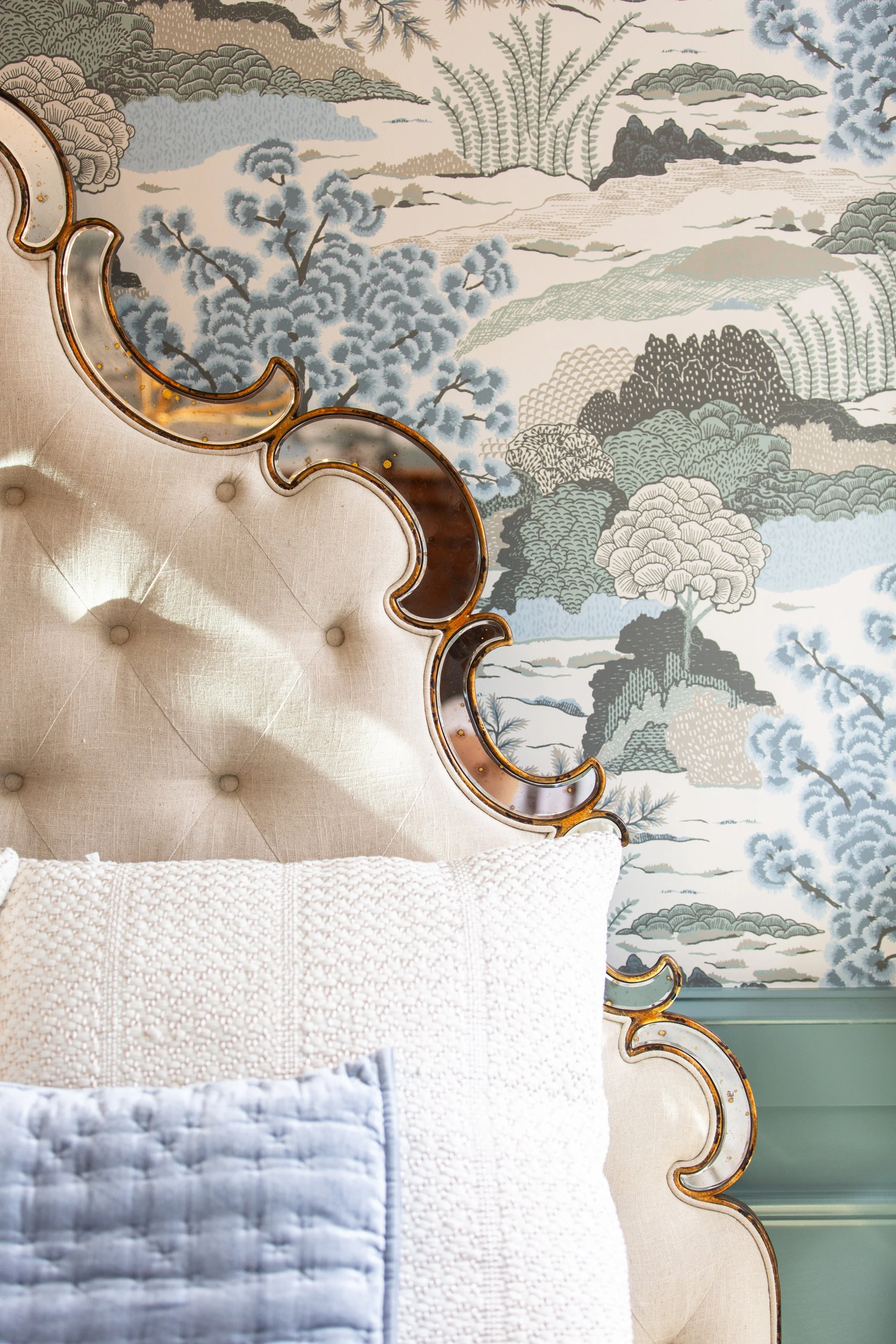 Custom bedroom design featuring patterned wallpaper and upholstered headboard
