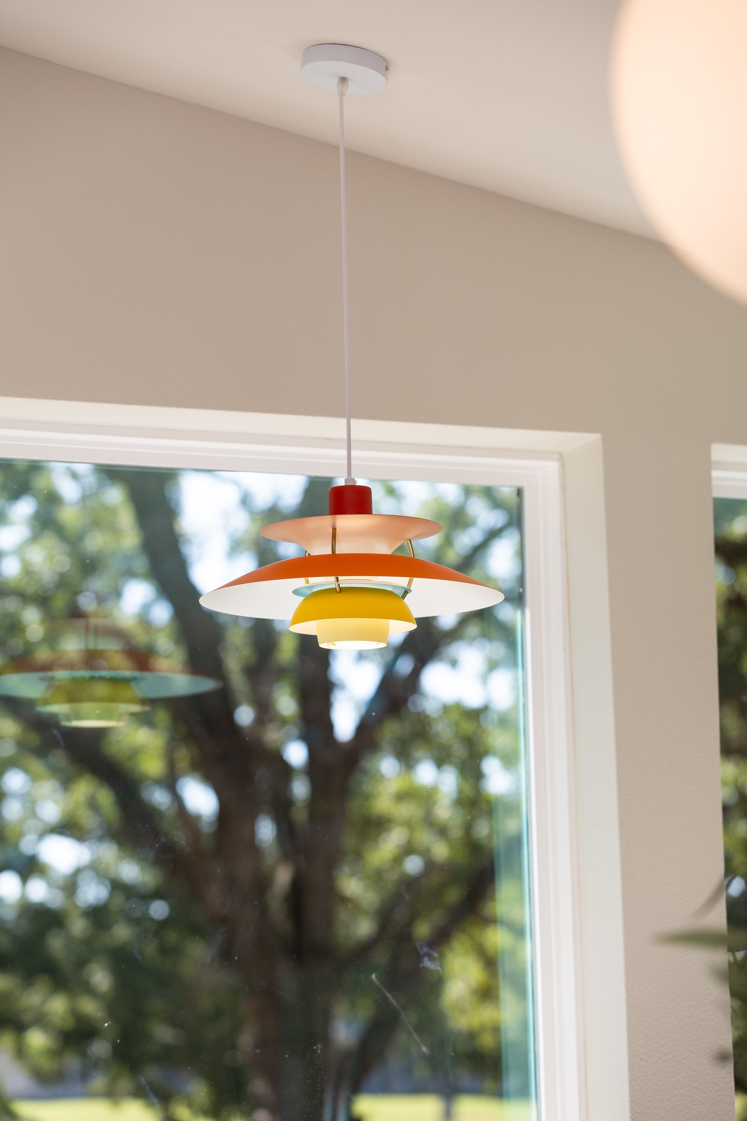 Colorful Scandinavian pendant light adding personality and modern design to a bright interior space.