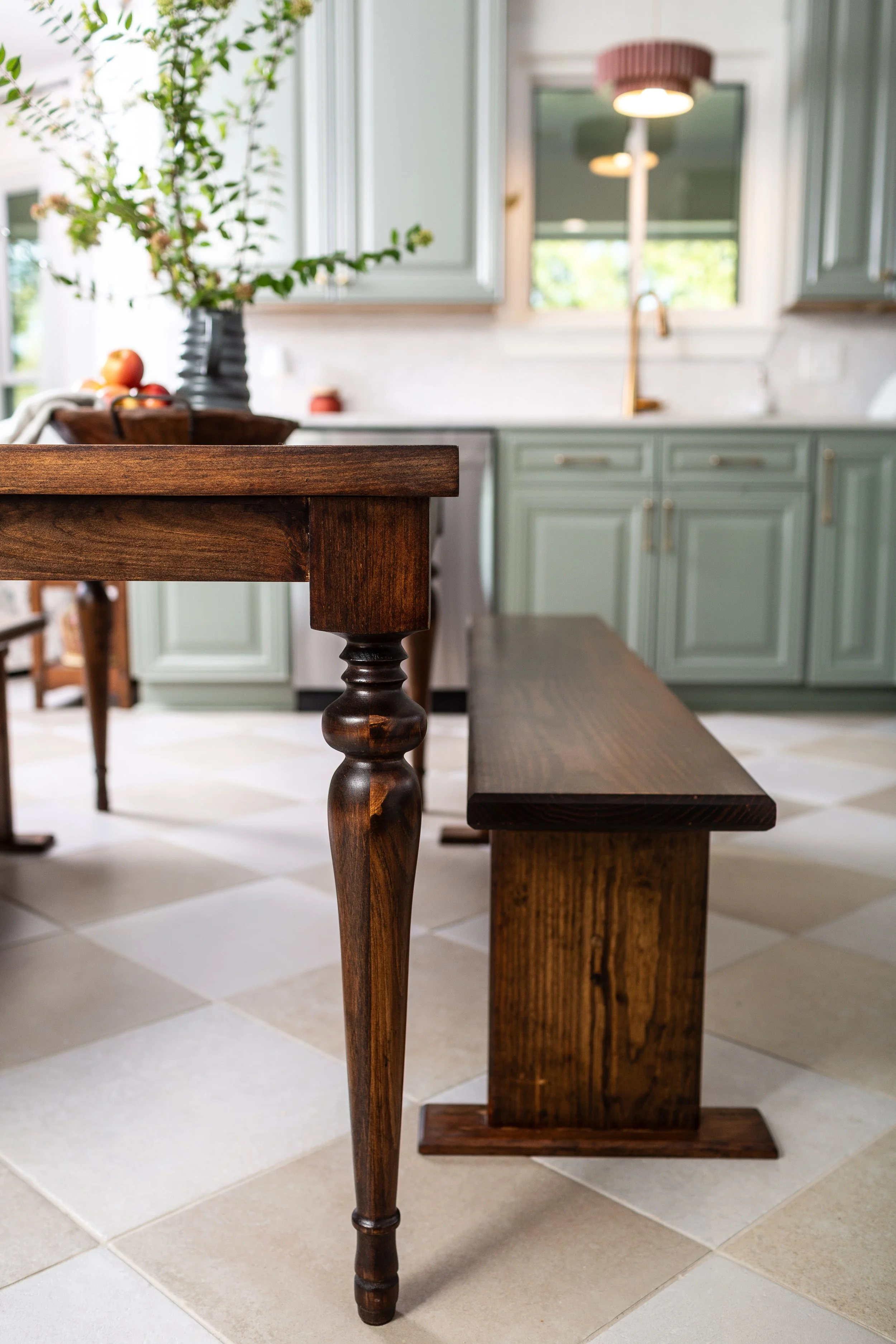 Traditional kitchen featuring sage green cabinetry, stained wood island, brass fixtures, and timeless finishes that blend classic and modern design.