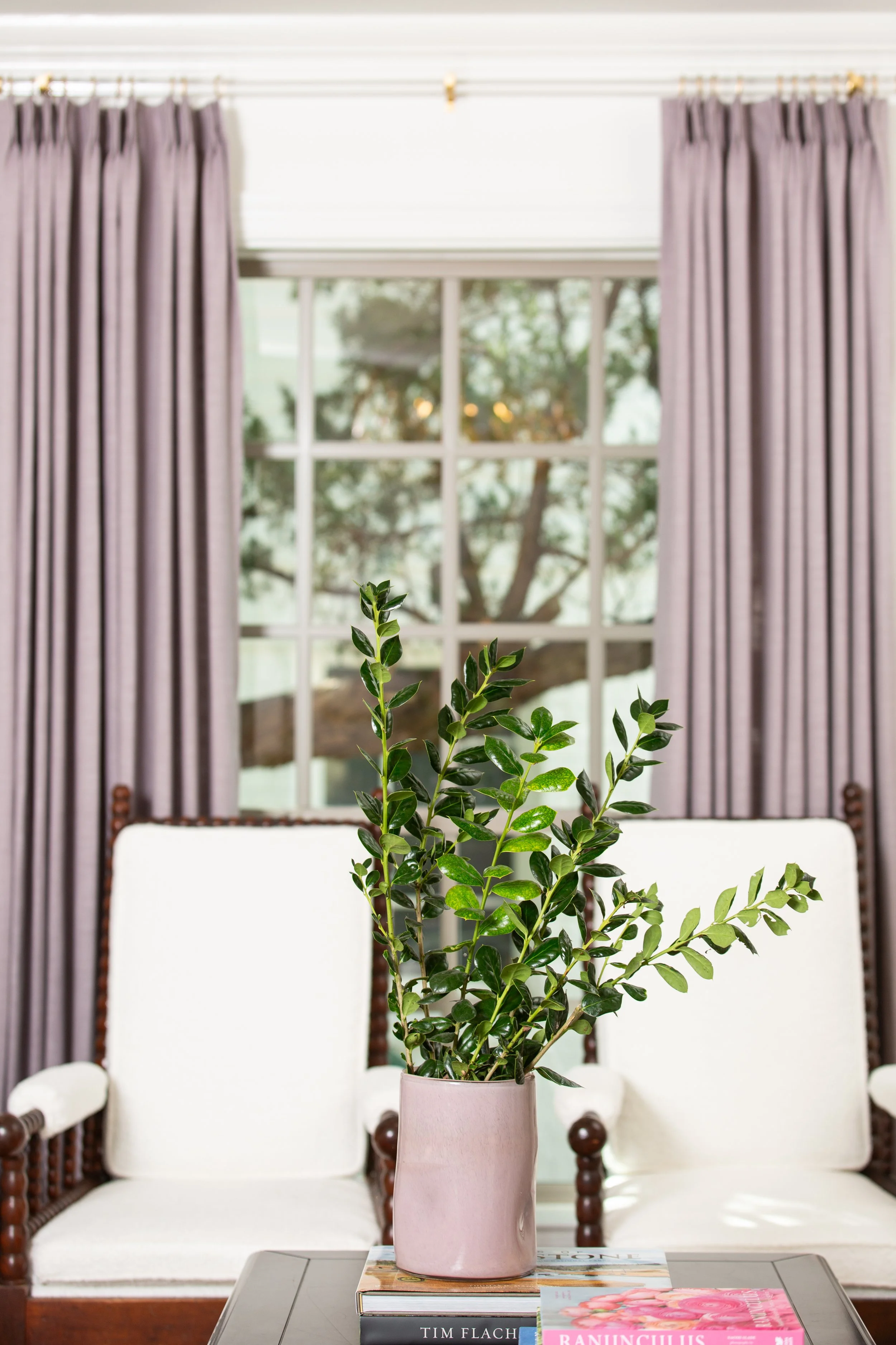 Comfortable living room with soft drapery, classic furnishings, and layered styling that reflects thoughtful, client-centered interior design.