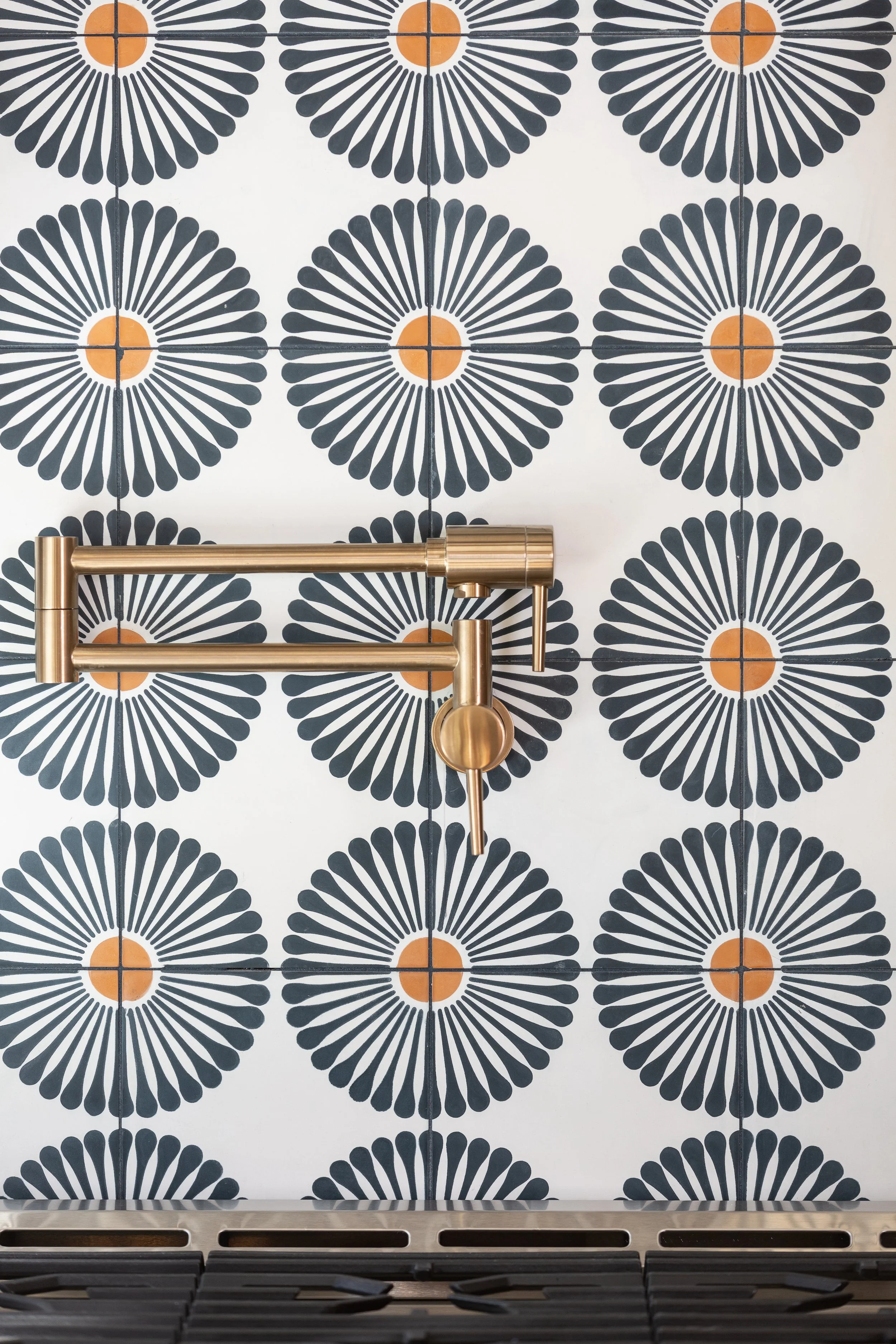 Statement kitchen backsplash with geometric patterned tile and brass pot filler, designed by MASH Habitat Interiors in Fort Worth, Texas.