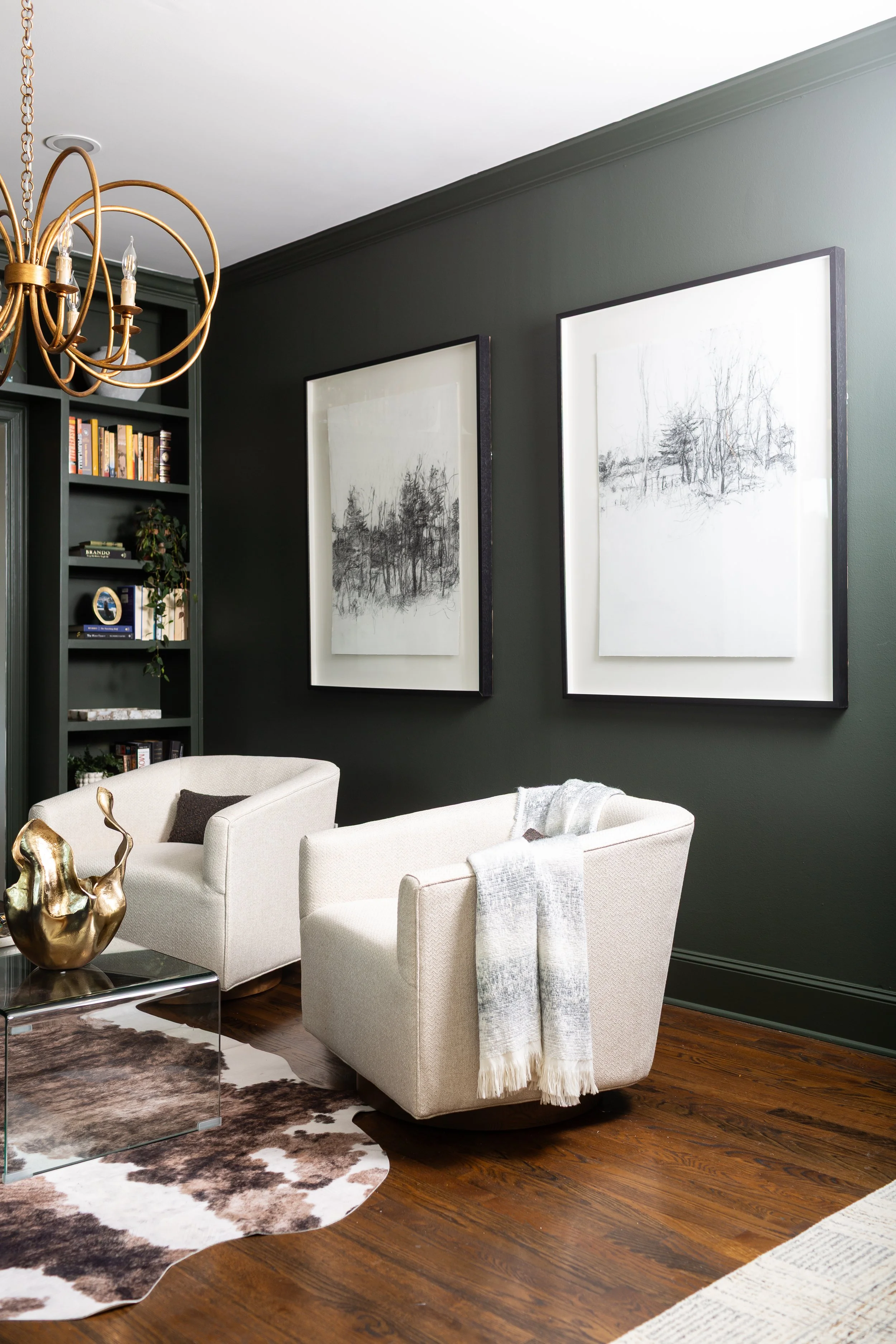 Timeless living room with deep charcoal walls, white swivel chairs, framed artwork, and classic furnishings designed to remain beautiful beyond changing trends.