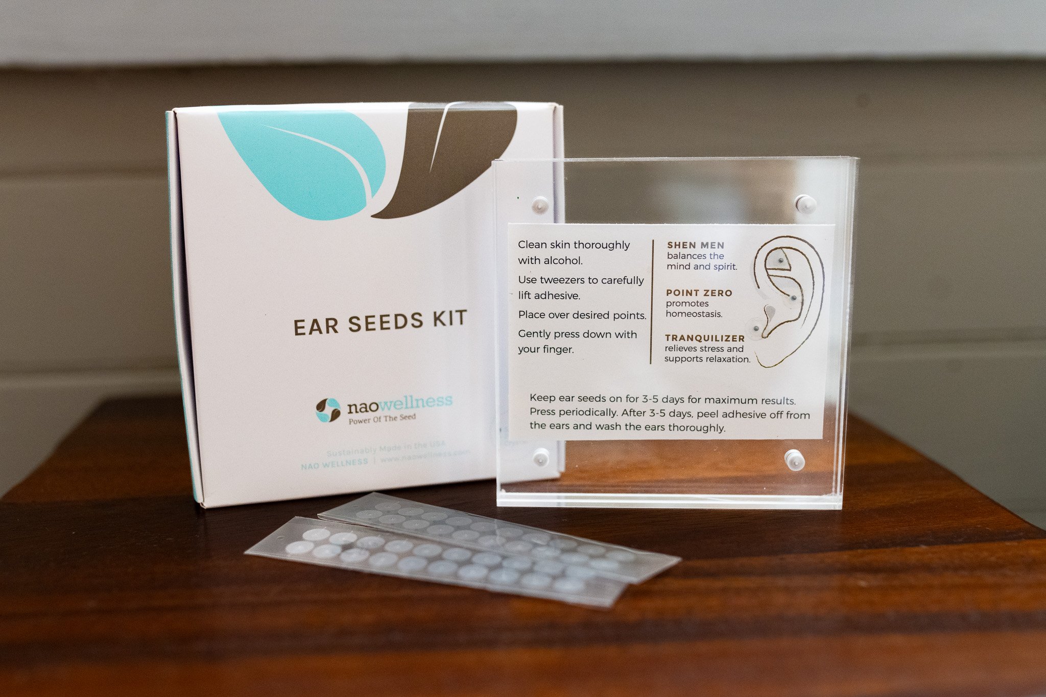 clear acrylic case featuring an anatomically correct ear and different pressure point options with benefits for the ear seed kit from naowellness, sold at Innovo health clinic.