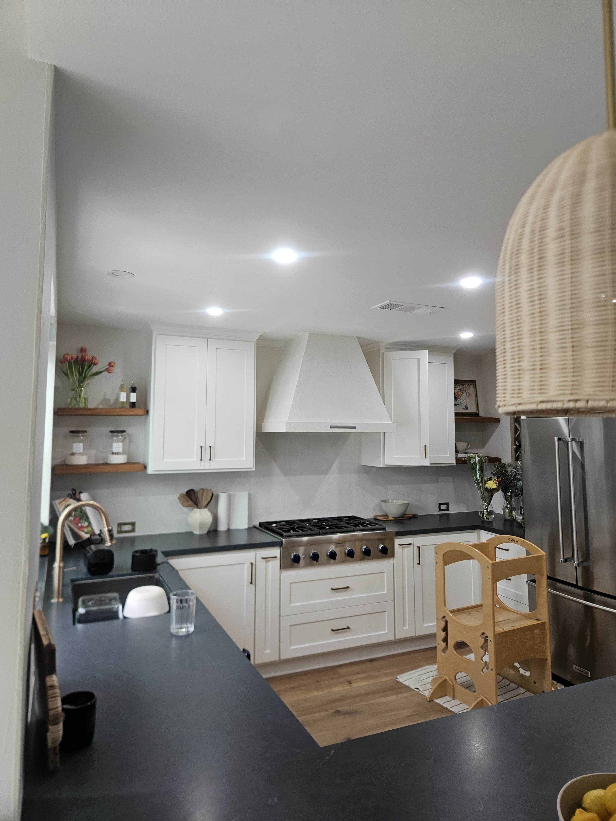 *AFTER* Micro cement was applied over the existing tile backsplash and range. The kitchen now looks brighter and updated.