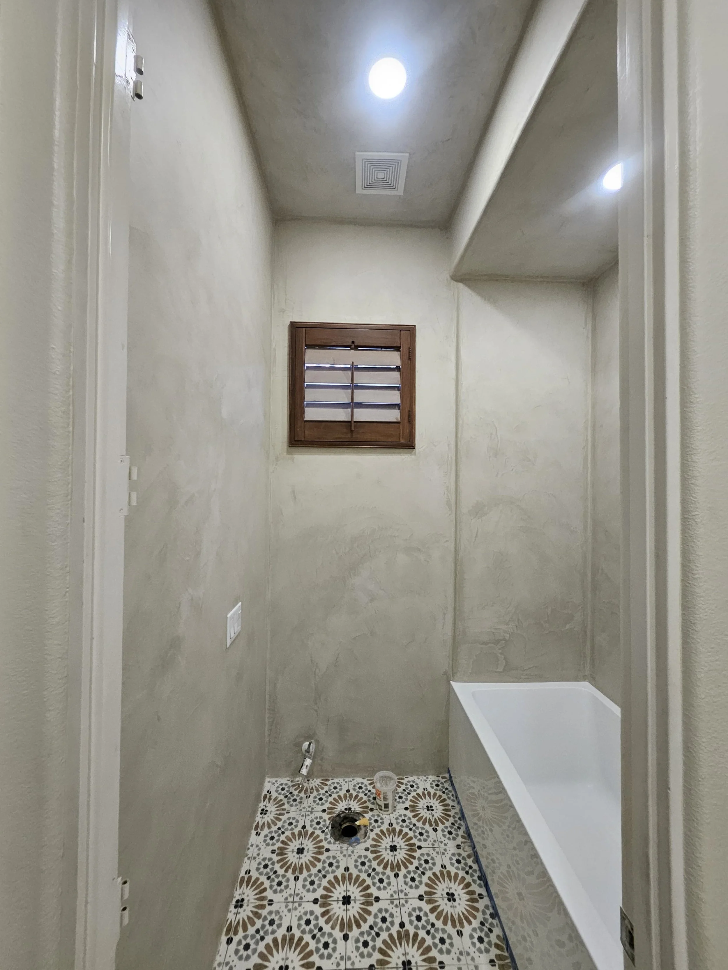 The micro cement in this bathroom complements the tile perfectly without stealing the spotlight.