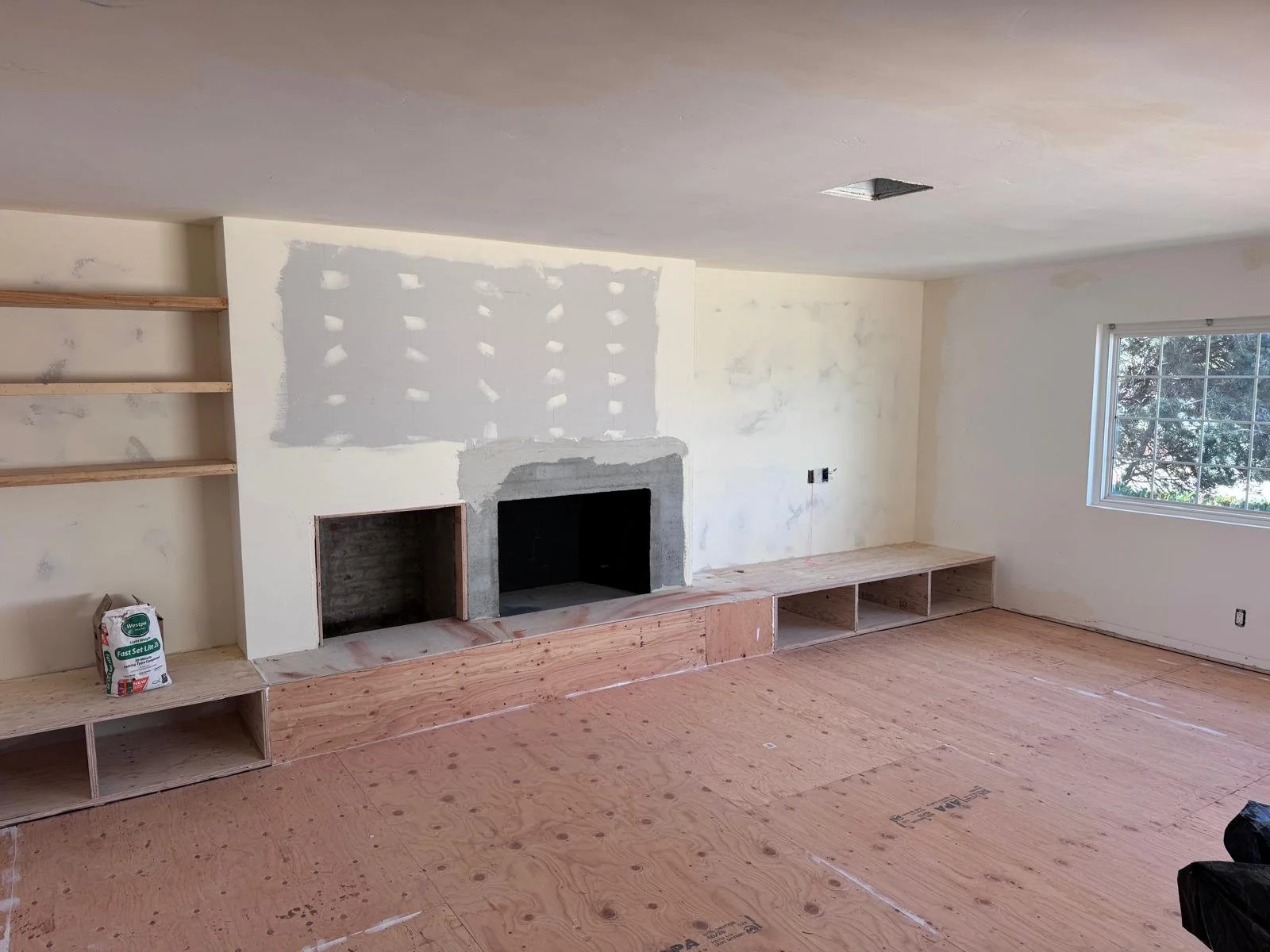 A progress picture of a fireplace and flooring.
