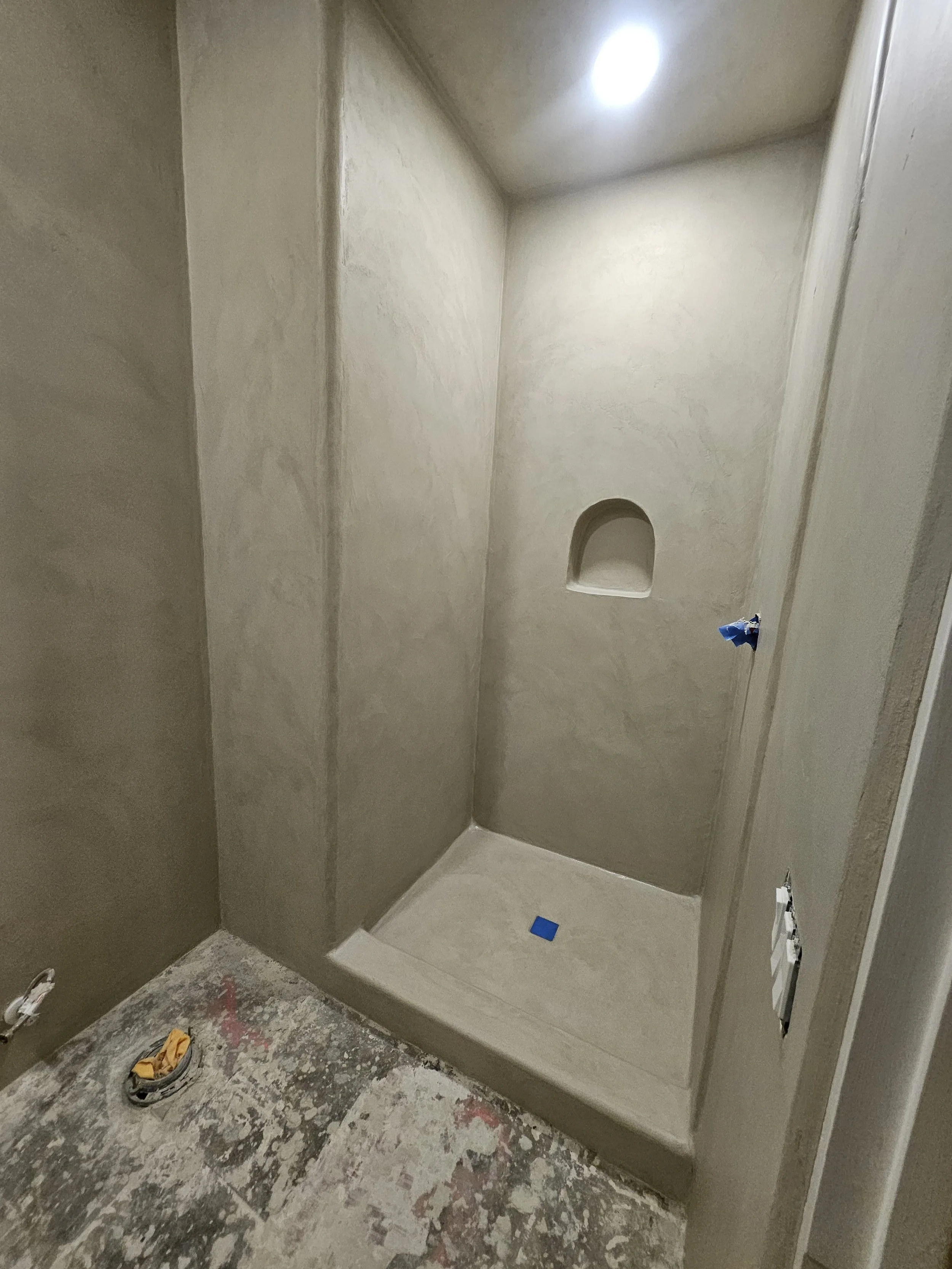A bathroom shower, ceiling, and walls all coated in micro cement.
