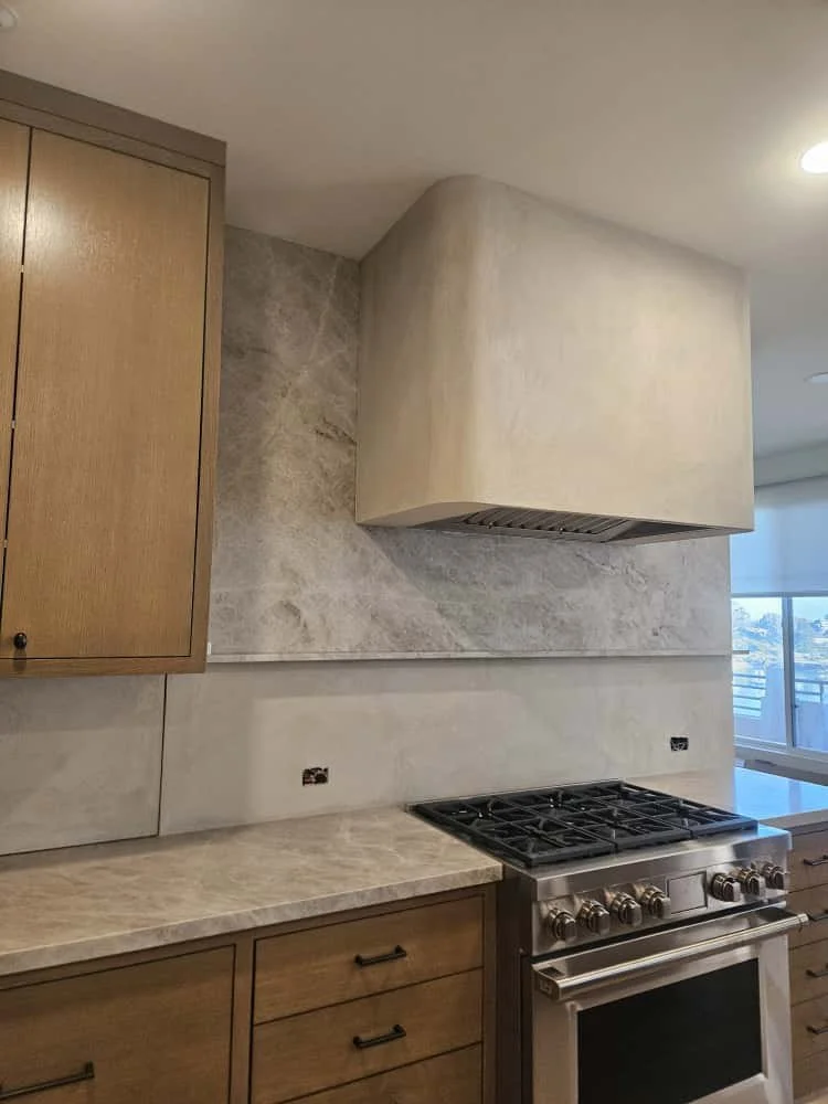 The range hood and part of the kitchen wall were coated in micro cement on this project.