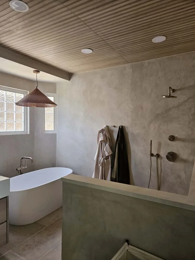 Micro cement creates a seamless, monolithic look in this bathroom. Color shown is "Baked Clay."