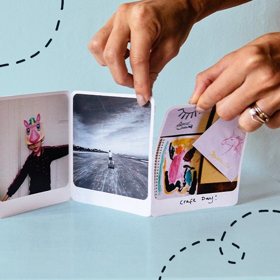 Hands separating card panels using perforations