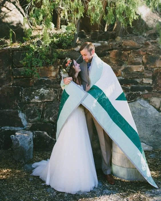 Wedding couple wrapped in ceremonial blanket