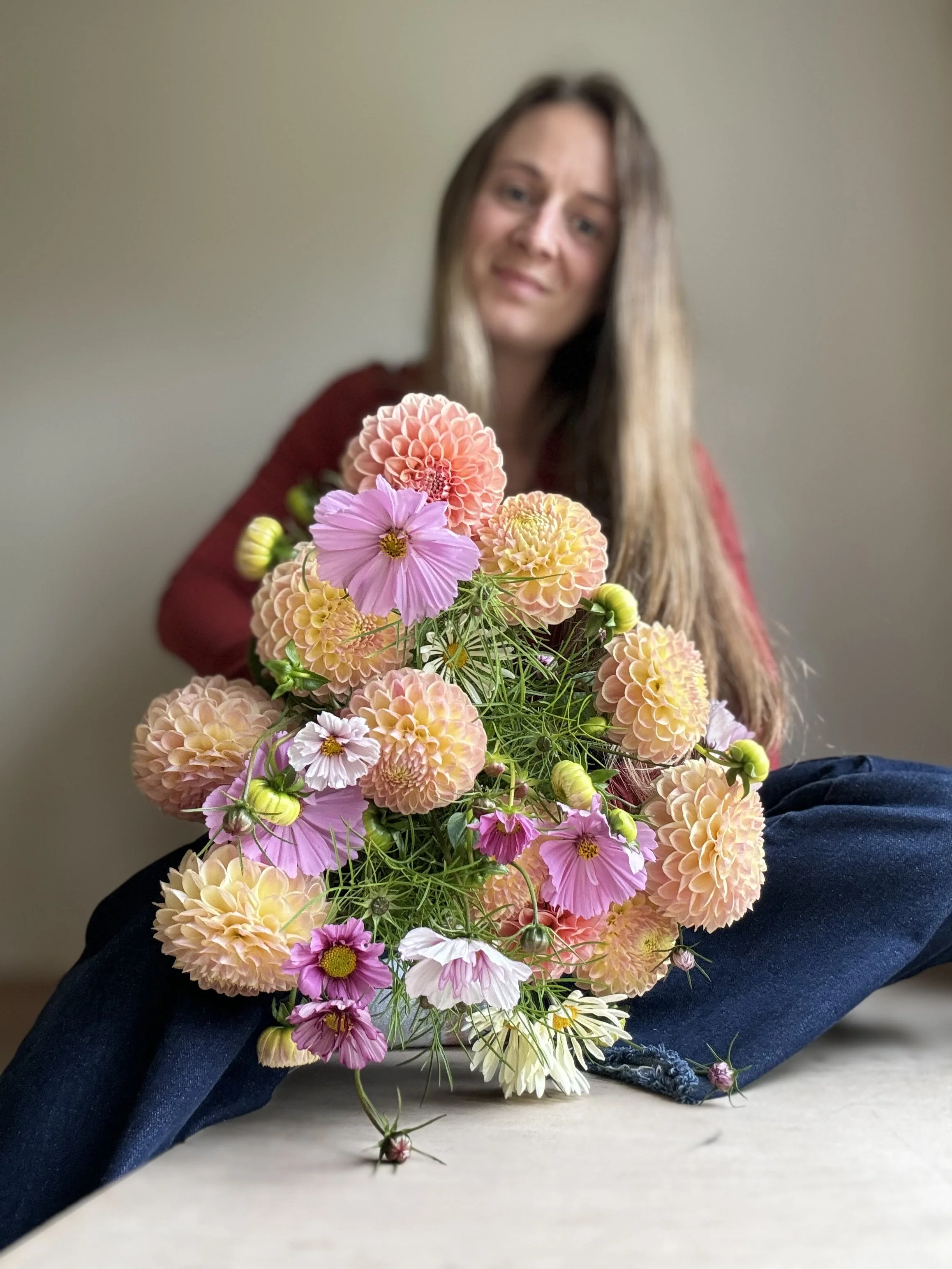 Alicia holding a bouquet of dahlias and cosmos