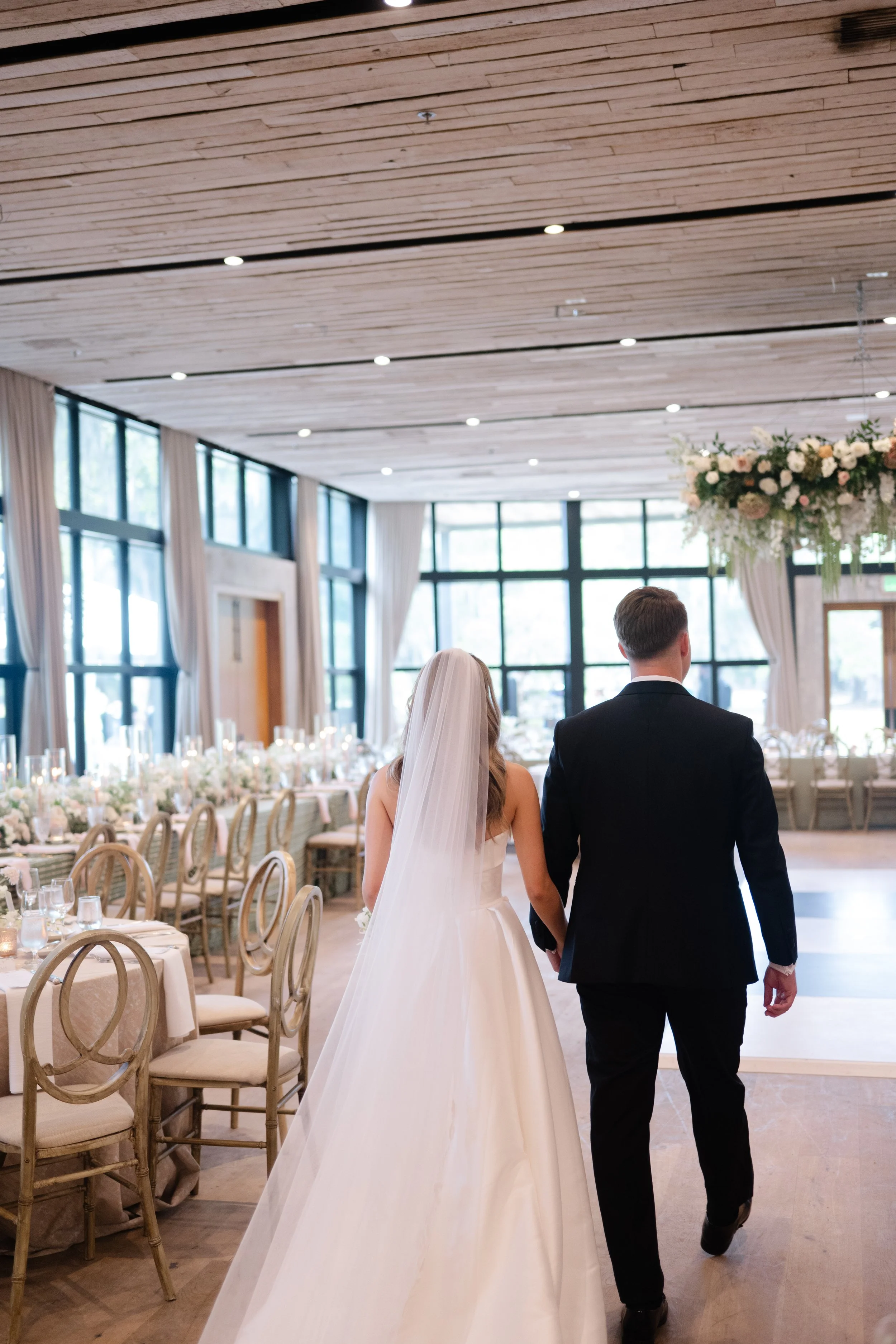 bride and groom walk into reception at middleton place to full lush floral design