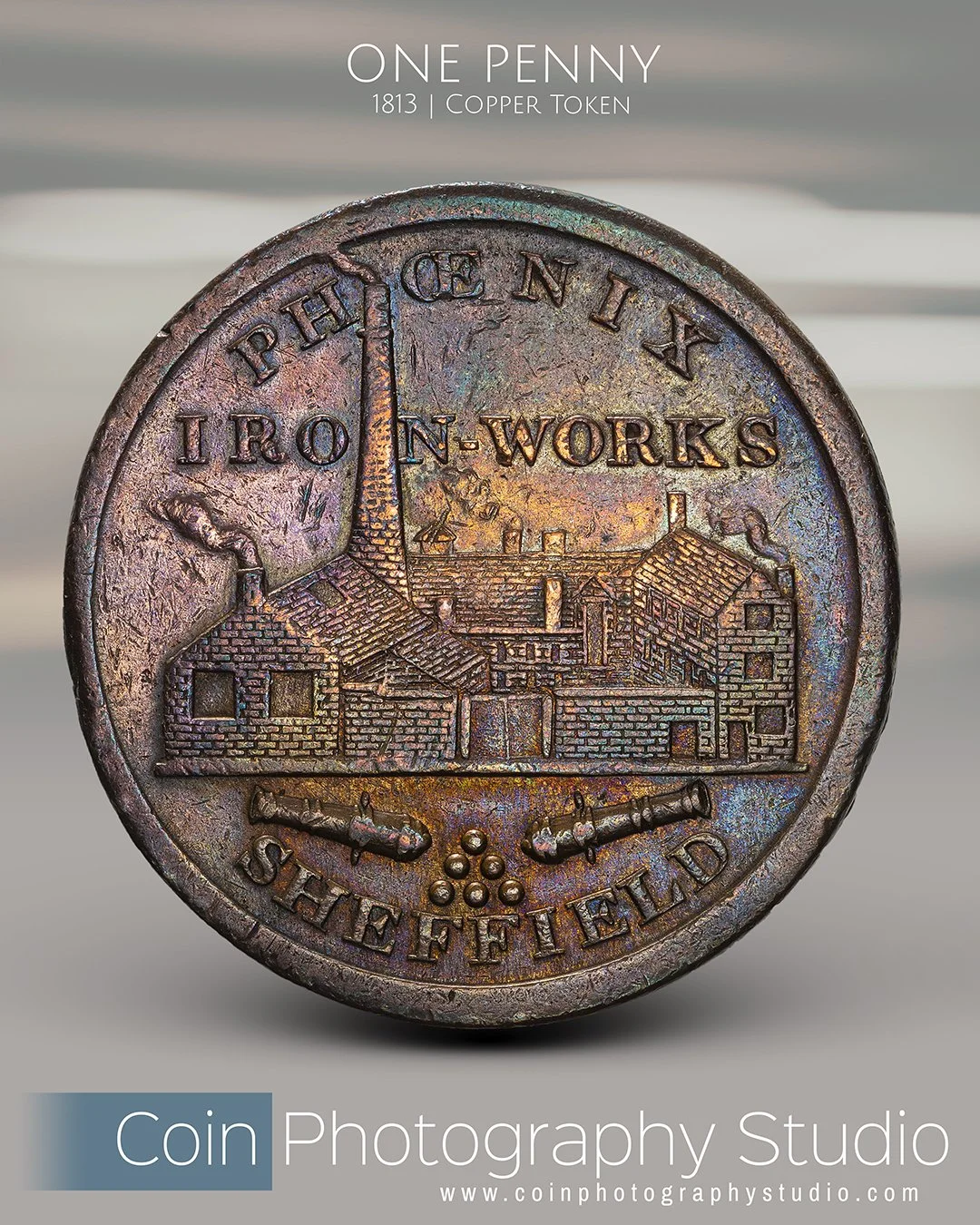Close-up photo of a vintage copper penny from 1813 with the text 'ONE PENNY', depicting an ironworks factory with smokestacks. The penny also includes the phrases 'PEACE N X' and 'SHFFIELD'.