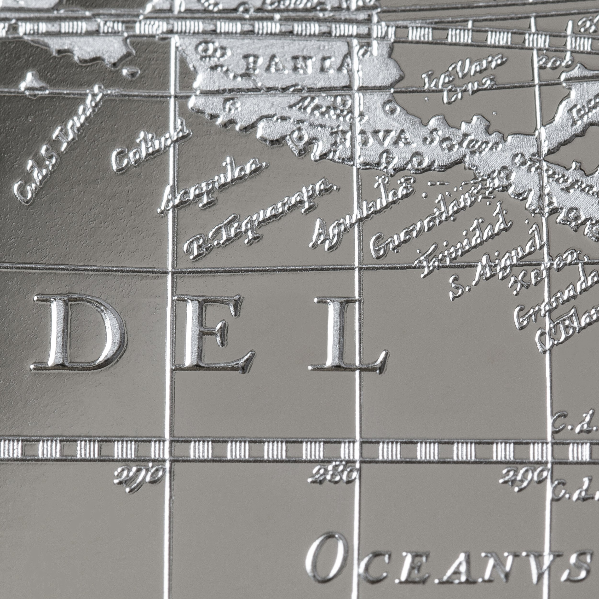 Close-up of a metallic map with the word "DELI" engraved, showing various oceanic regions and countries in the Pacific, Atlantic, and Indian Oceans.