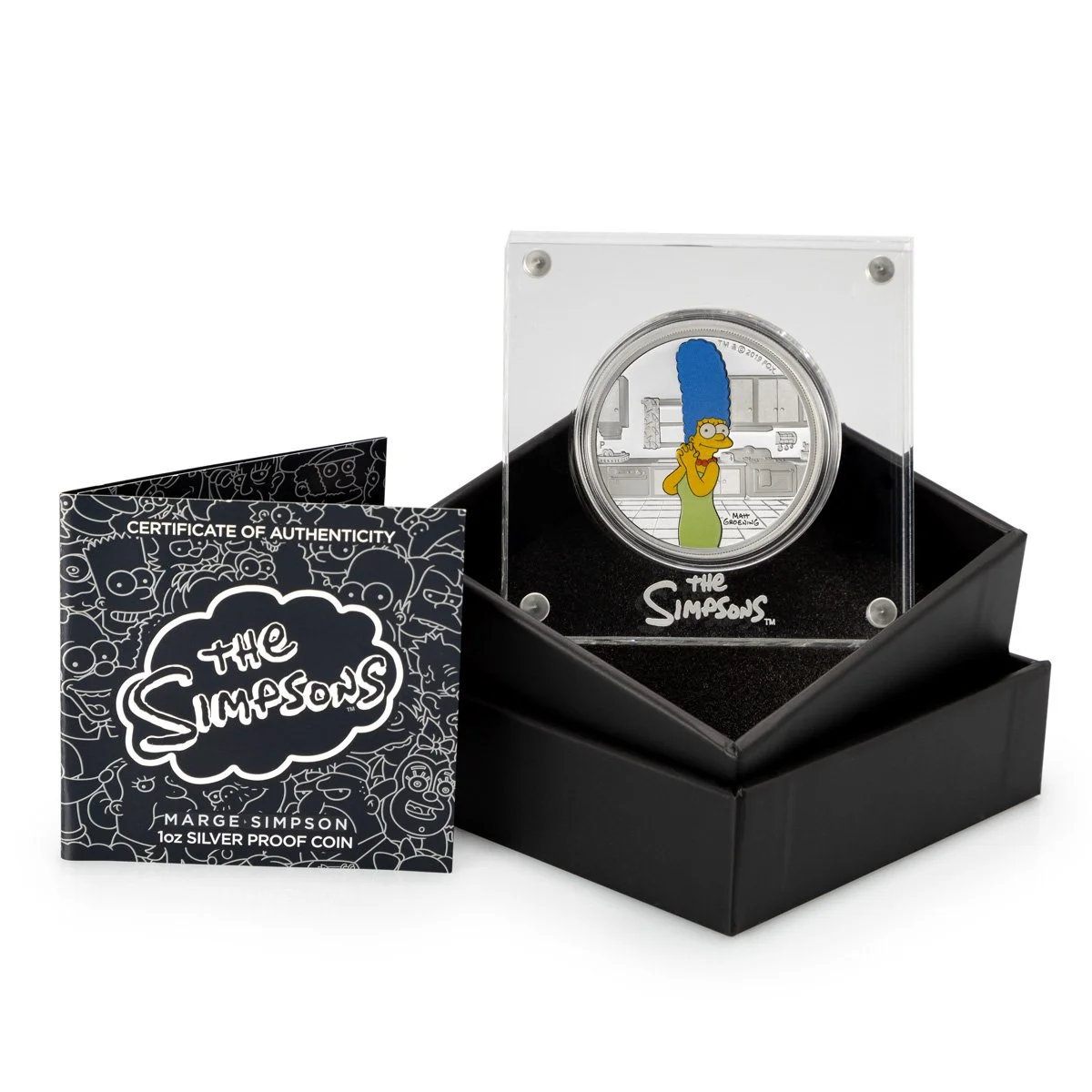 A limited edition silver proof coin featuring Marge Simpson from The Simpsons inside a display case, with a certificate of authenticity beside it.