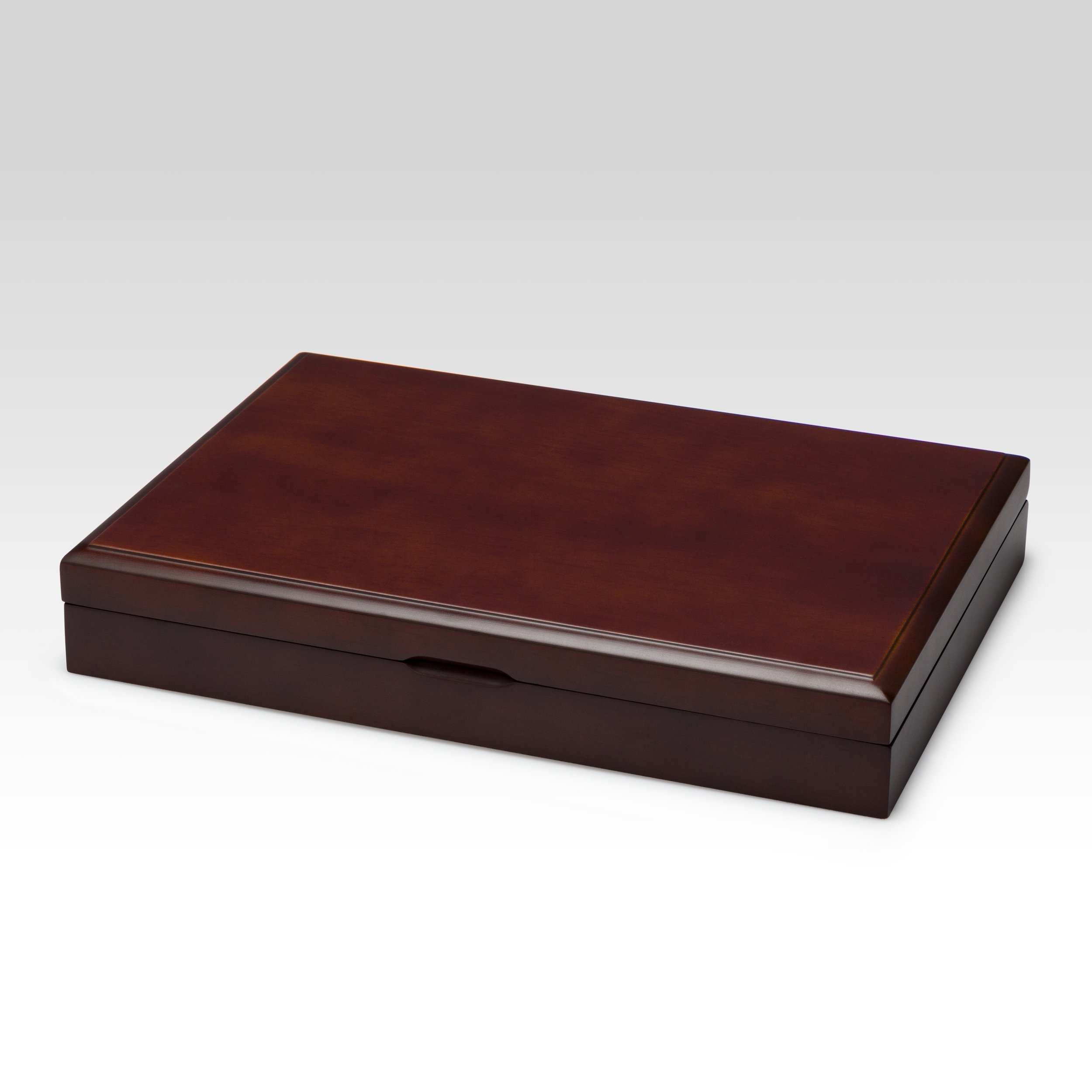 A closed wooden box with a polished dark brown finish, rectangular shape, and a subtle groove for opening against a white background.