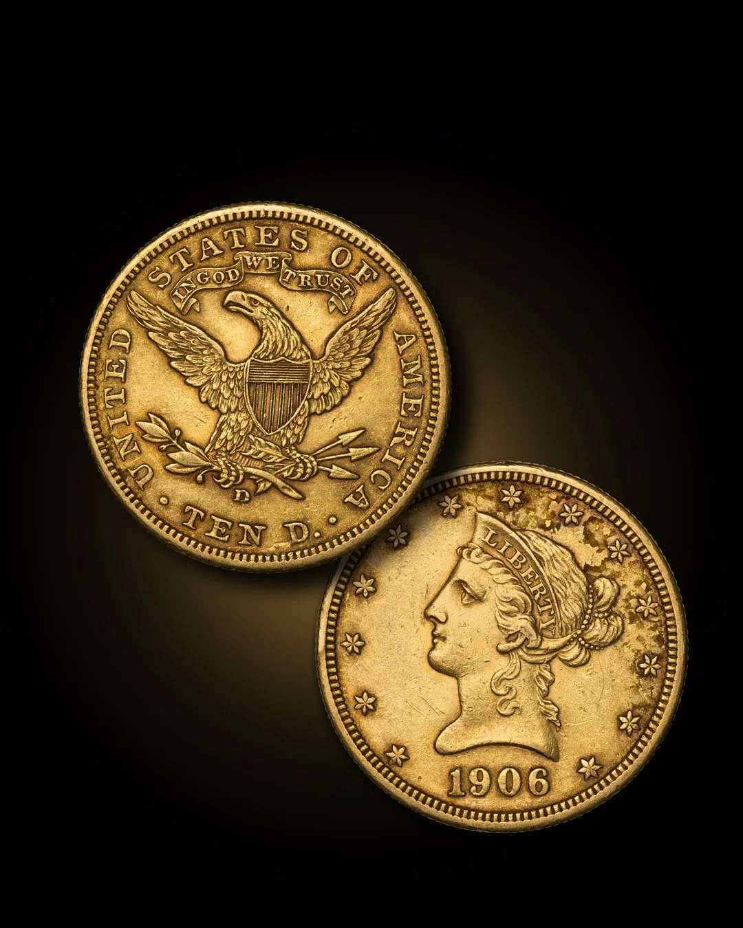 Two gold coins, one showing the reverse side with an eagle, shield, and inscription, and the other showing the obverse side with a profile of Lady Liberty and the date 1906, on a black background.
