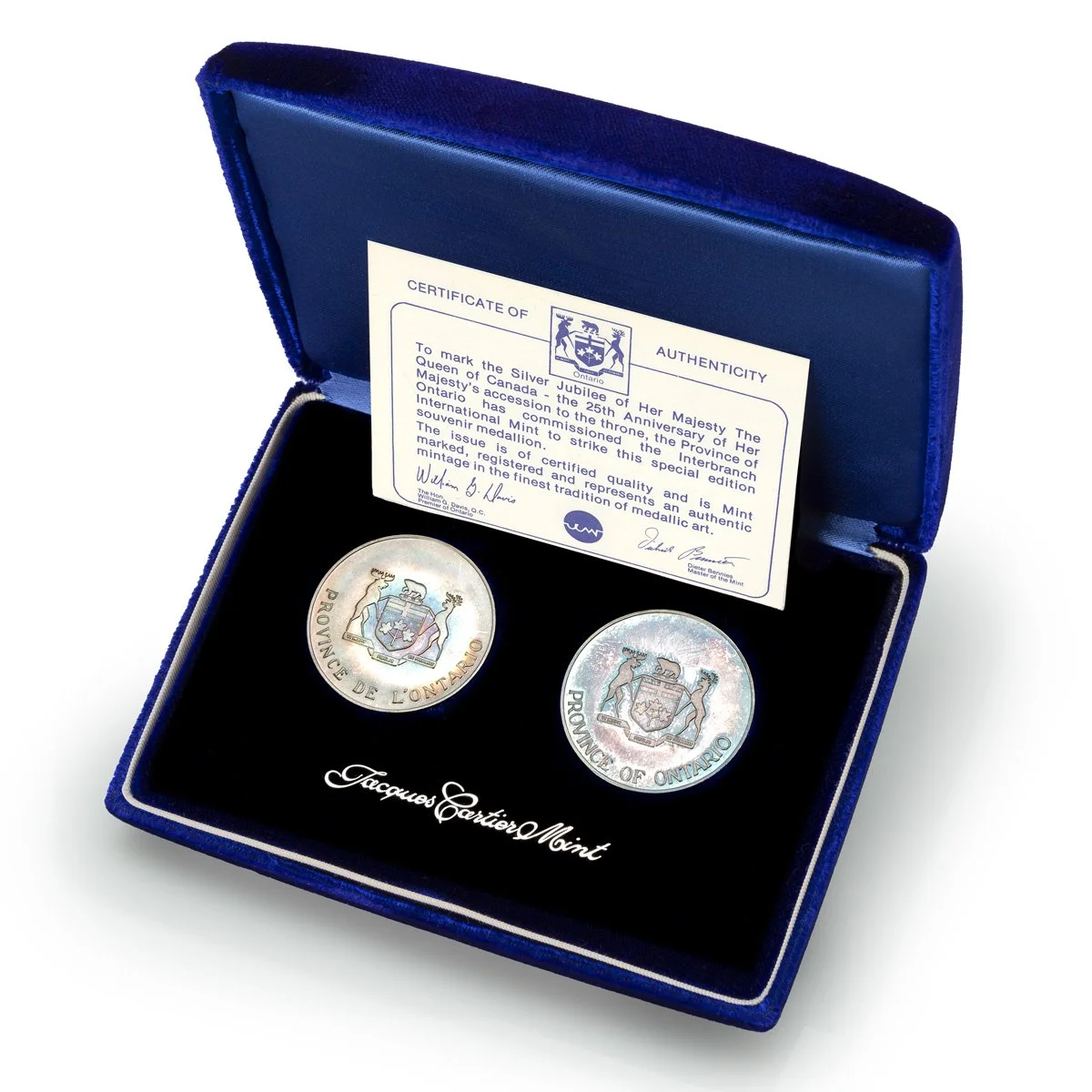 Silver coins in a blue presentation case with the Ontario coat of arms and signatures, commemorating the Queen of Canada's Silver Jubilee with a certificate of authenticity.