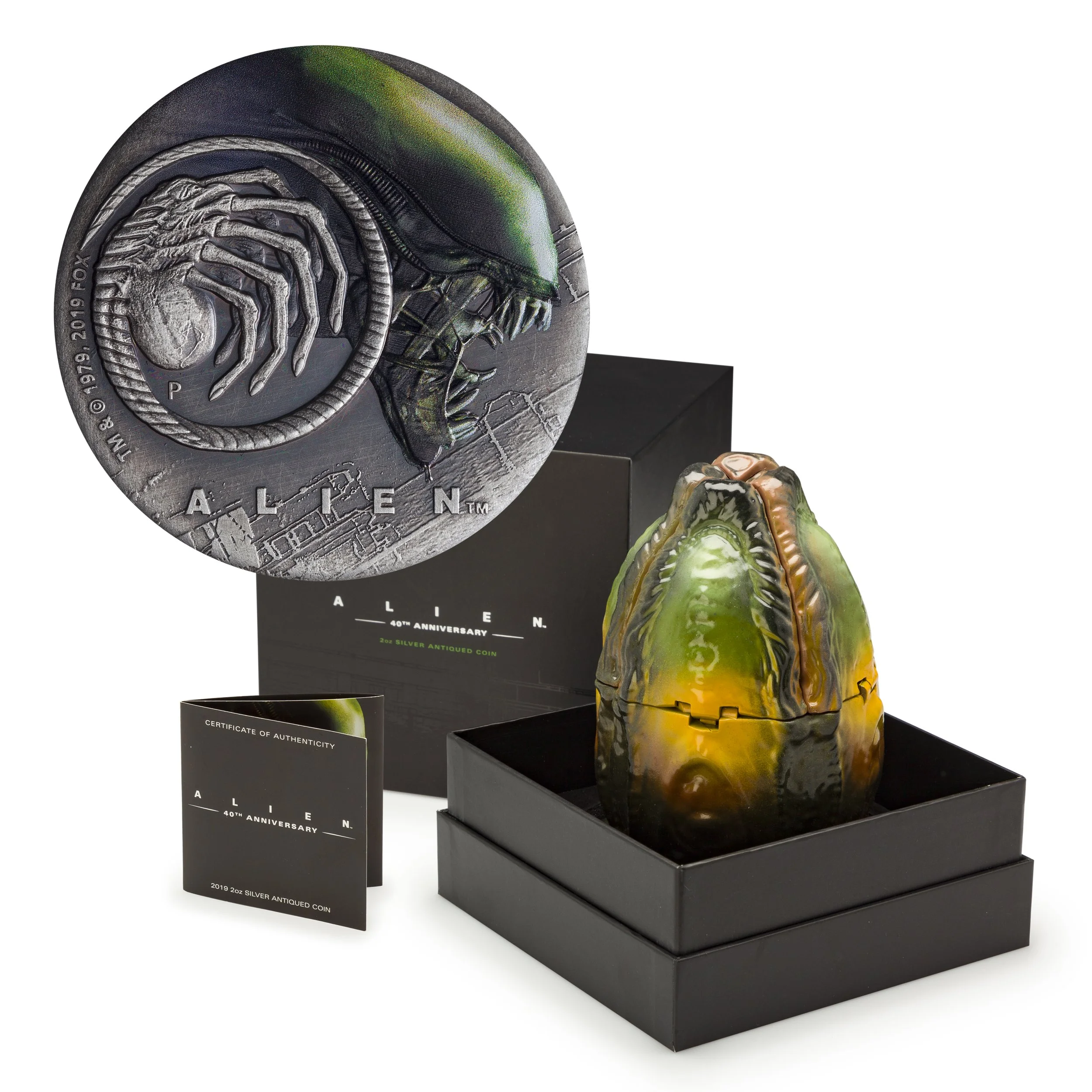 Alien 40th Anniversary silver coin displayed with collectible case shaped like an alien egg and certificate of authenticity.