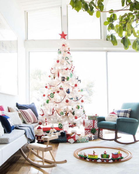  I love the white tree with the more classic colors of Christmas - red and green. &nbsp; It looks great in this sun filled room.  Image via  Domino  and  Em Henderson  