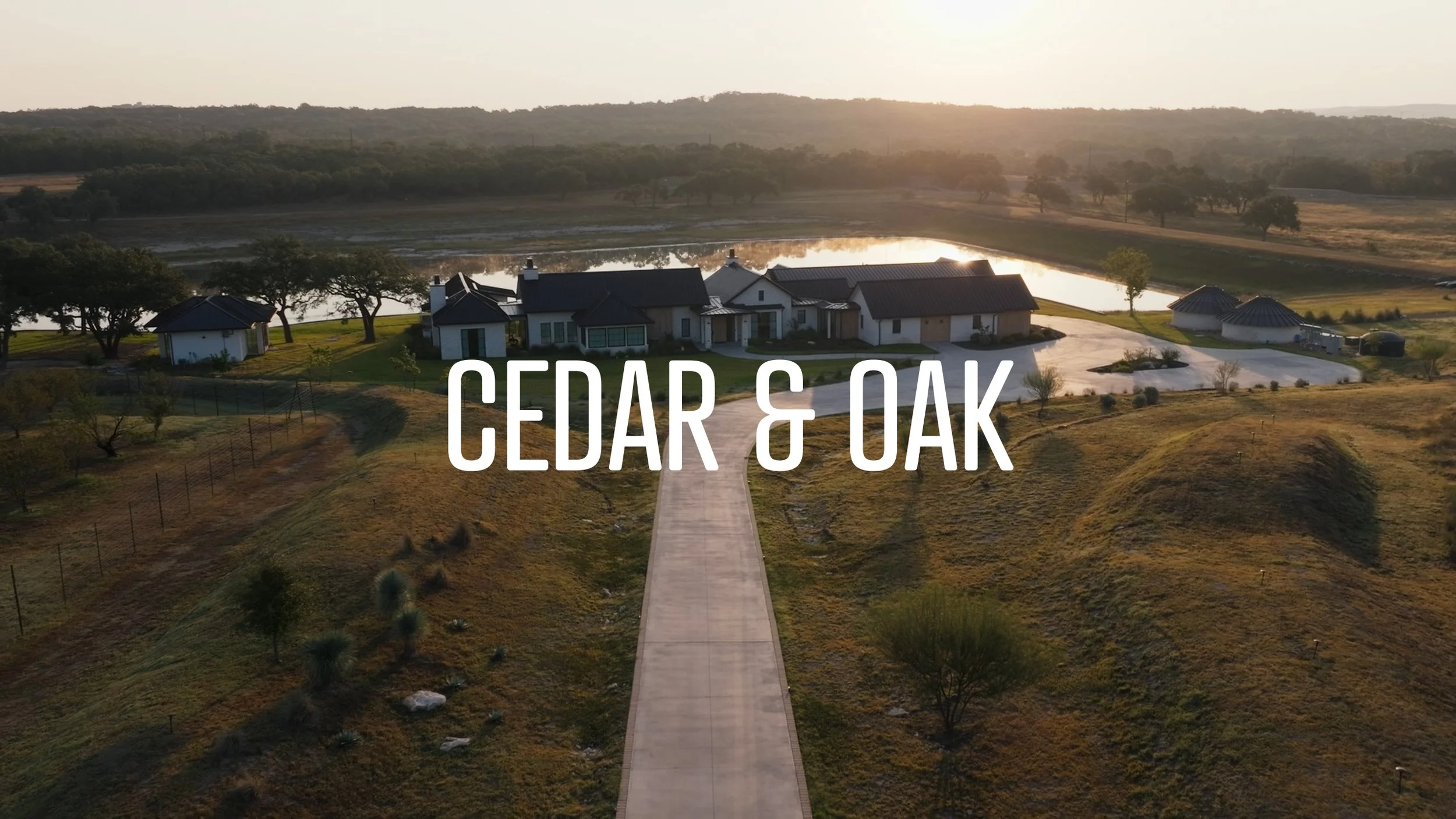 Two people in cowboy hats toasting with wine near a wooden fence, "Broadside Wine" text, countryside background.