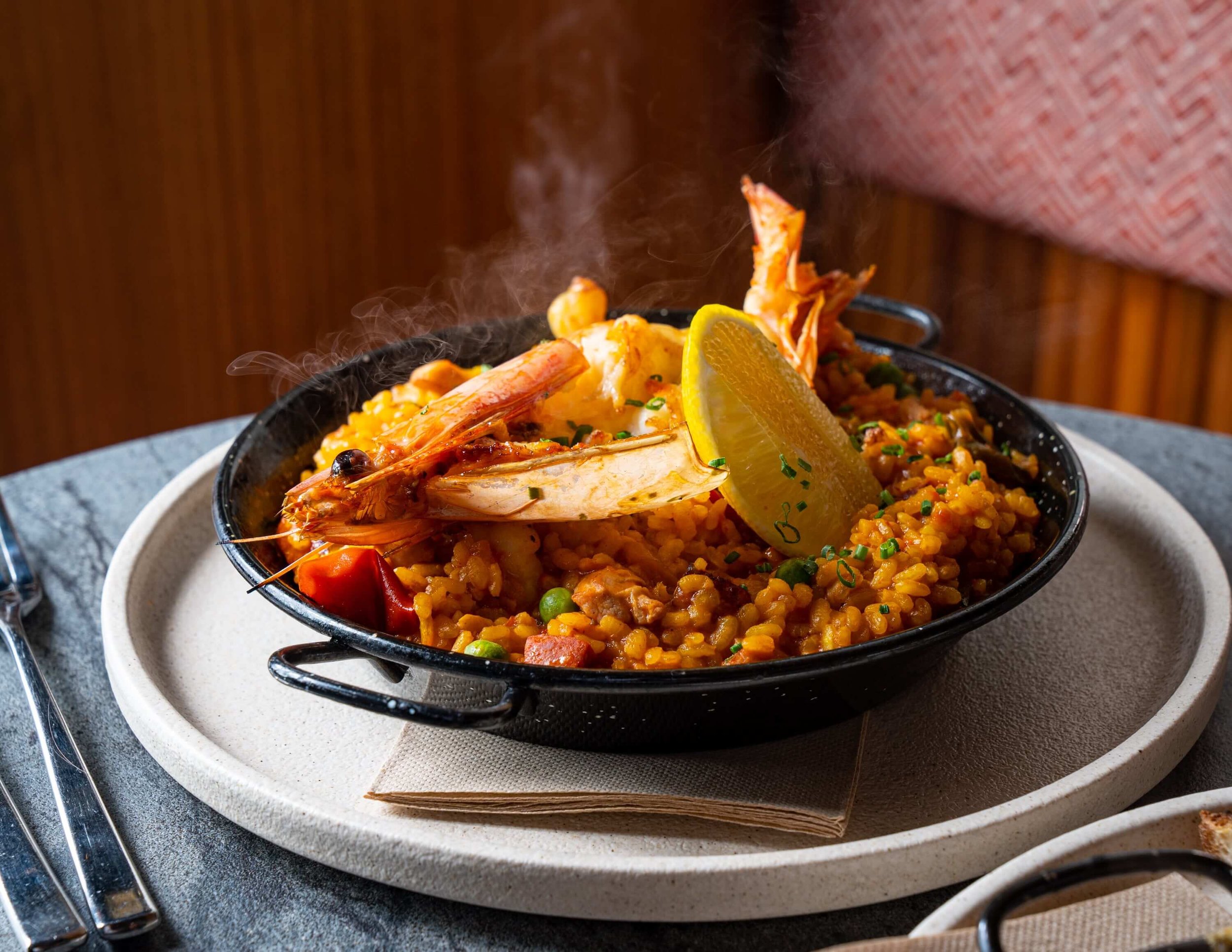  Steaming hot Prawns on a bed or Paella with a slice of lemon 