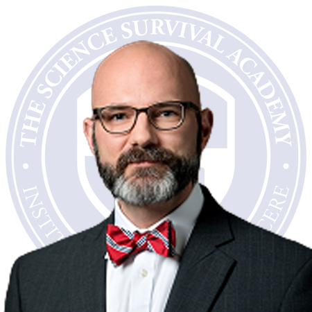 Logo of The Science Survival Academy featuring a shield with four icons: a building, an open book, a quill, and a closed book, with Latin motto beneath.