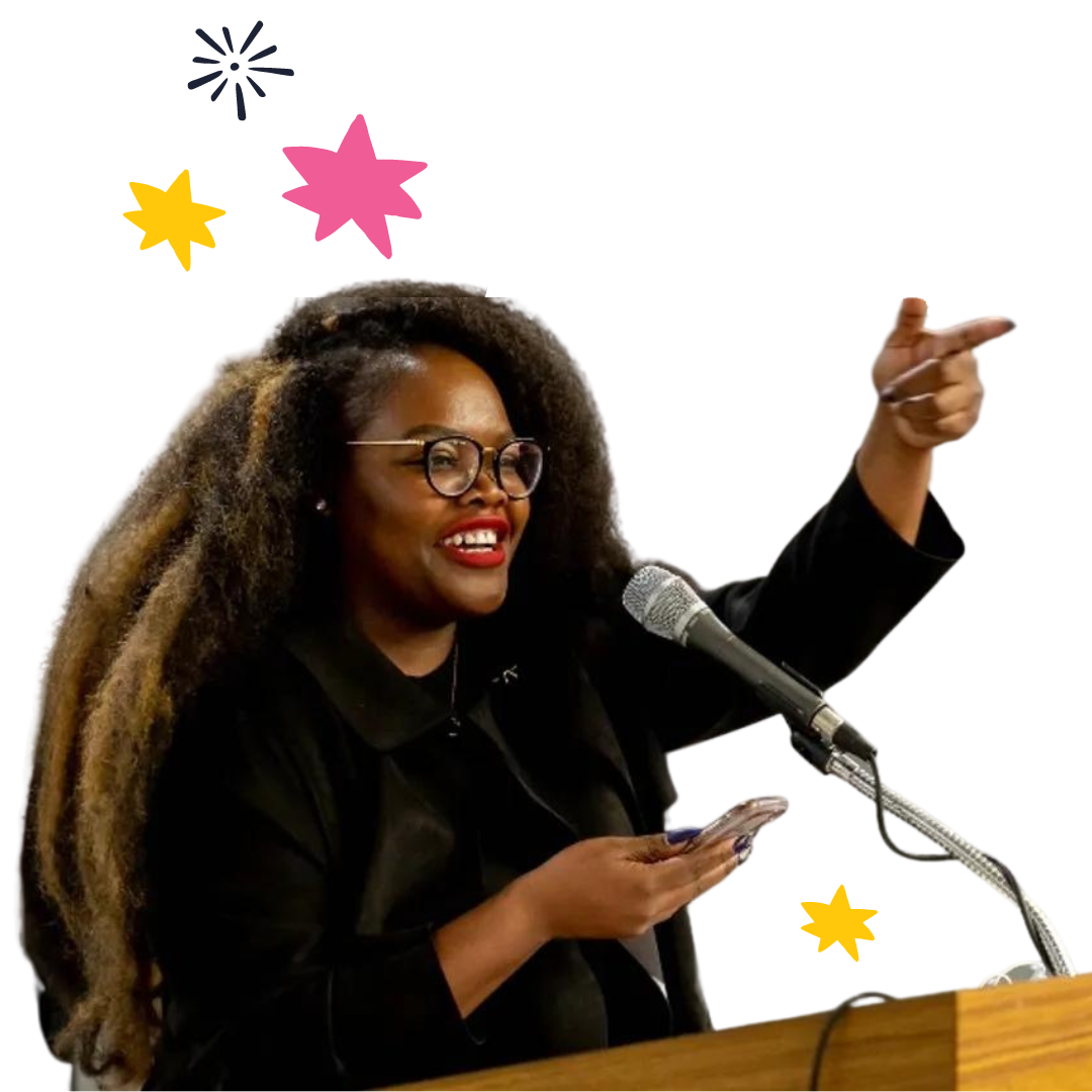 Shontel at a podium smiling and pointing into the crowd.