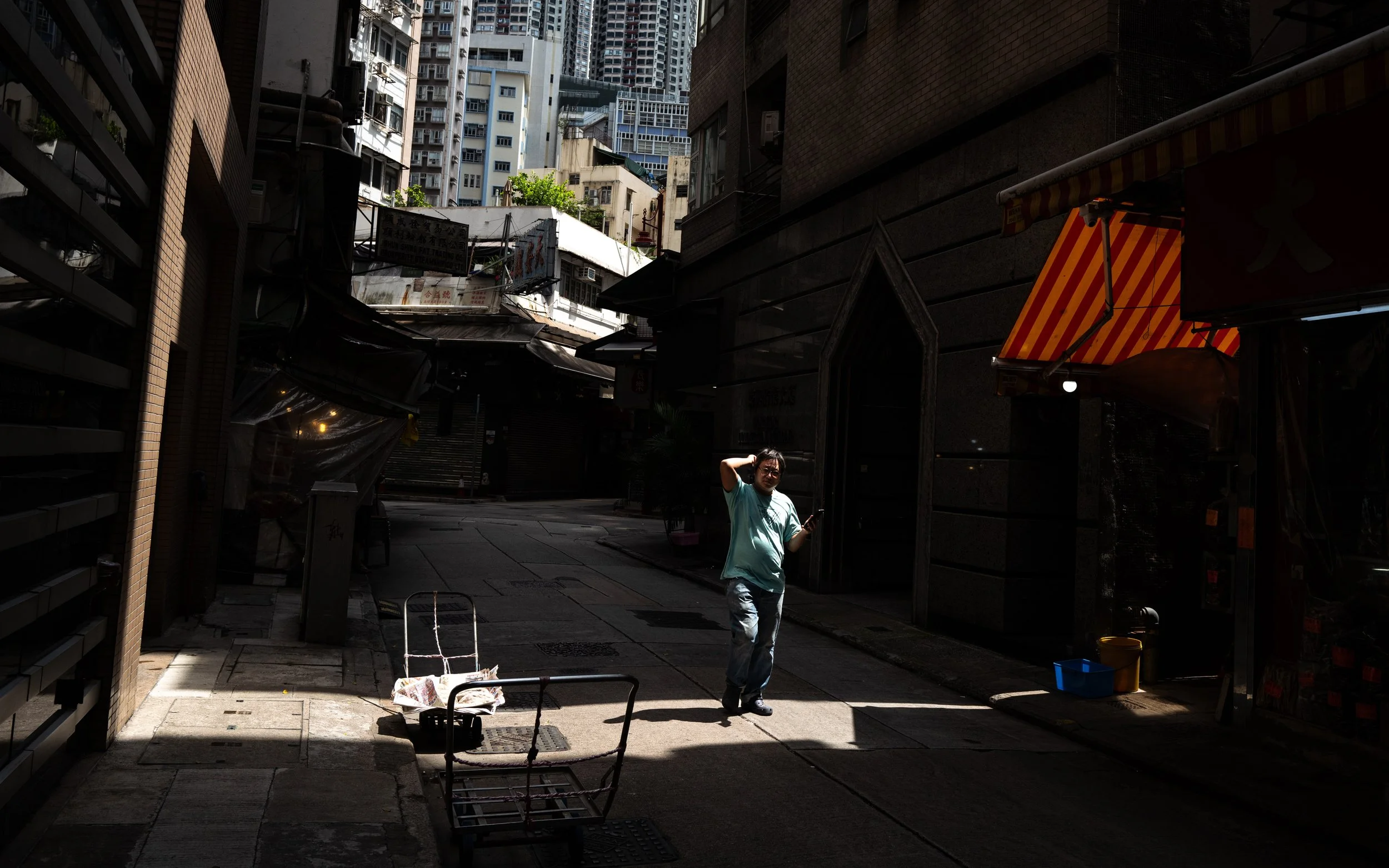 Street Photography of a man stepping in to the light in Sheung Wan, Hong Kong