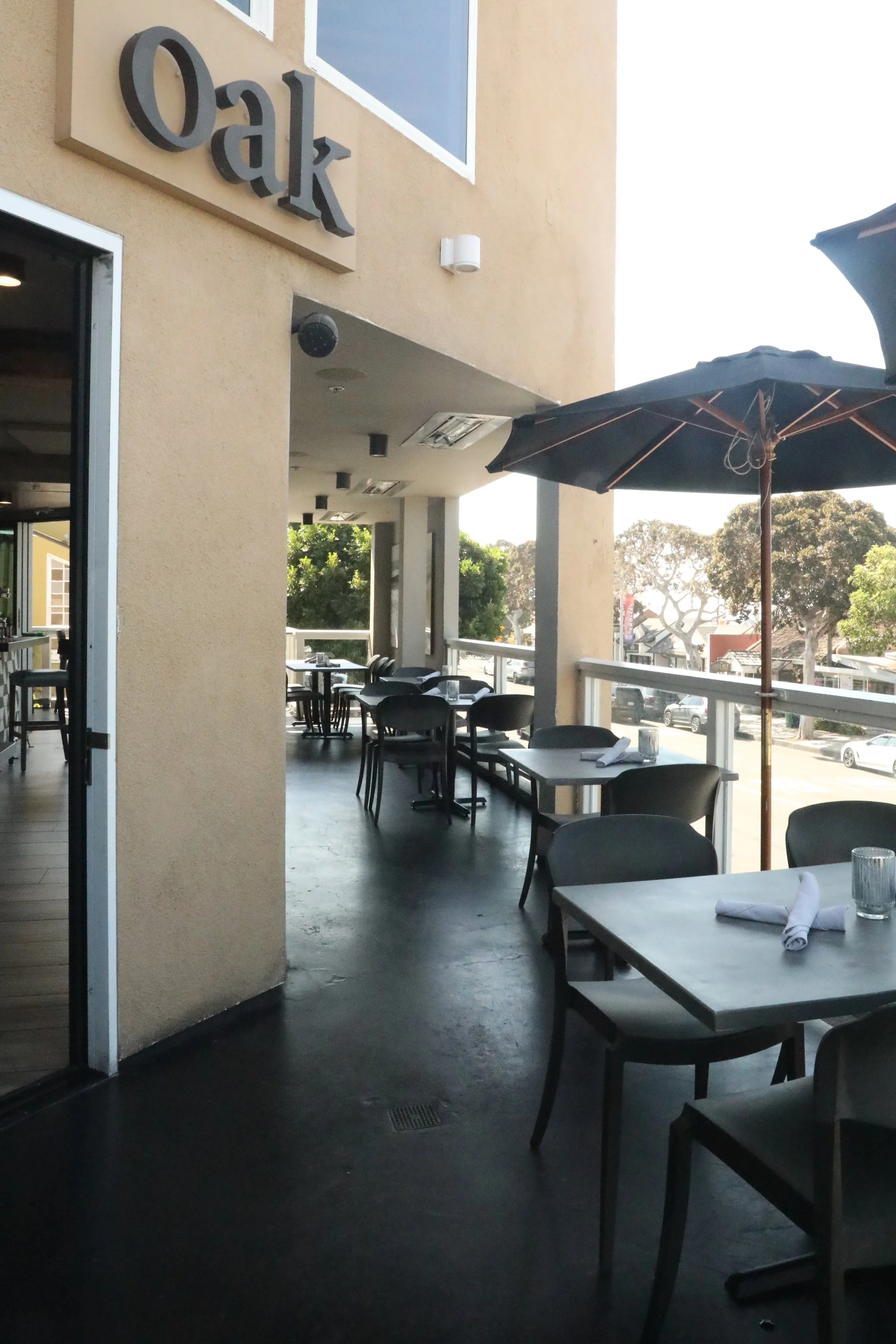 Outside patio deck with umbrellas, and our sign on side of building