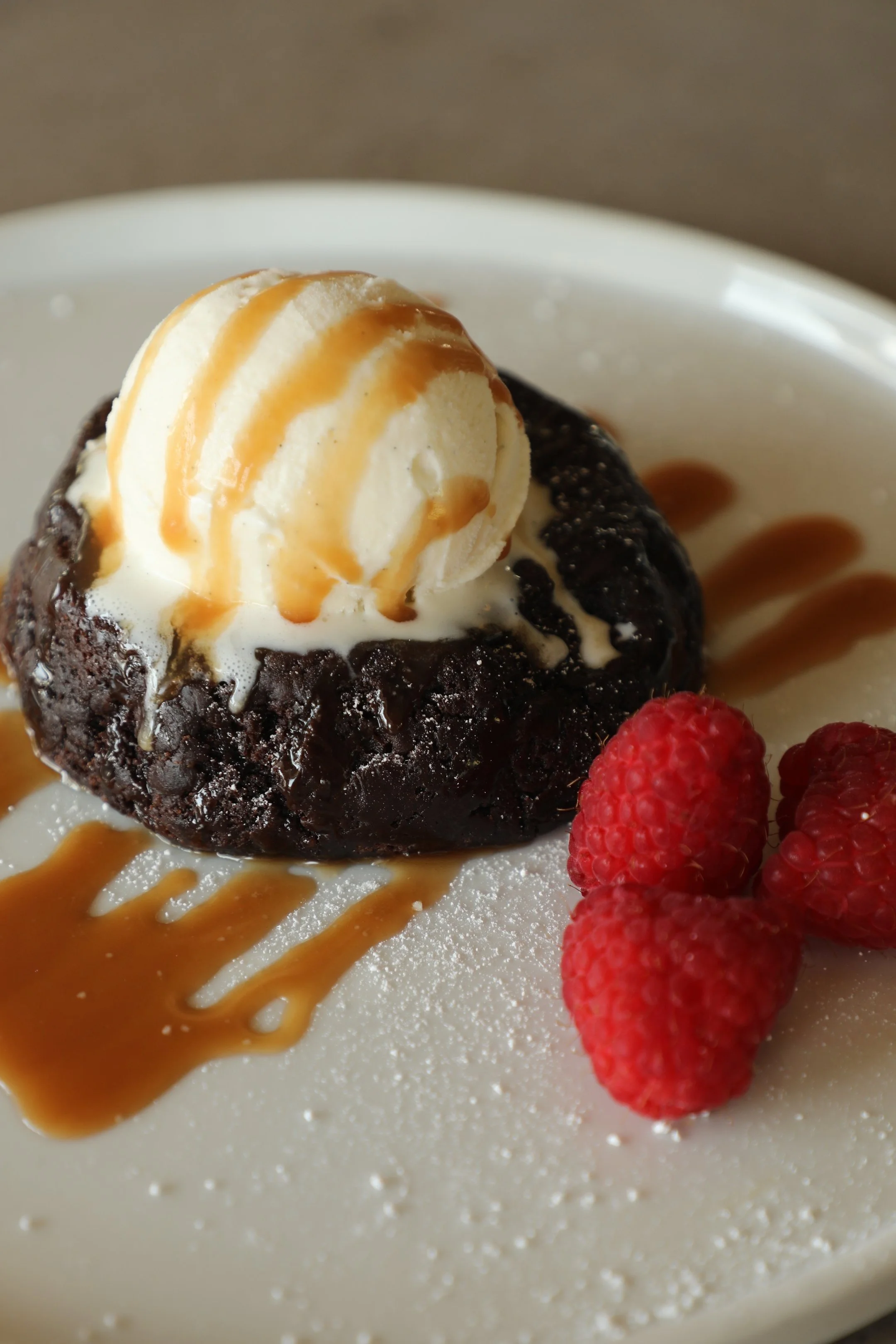 Our Br'oak'ie Dessert, a brownie and chocolate chip cookie combo with a drizzle of caramel, and garnished with raspberries