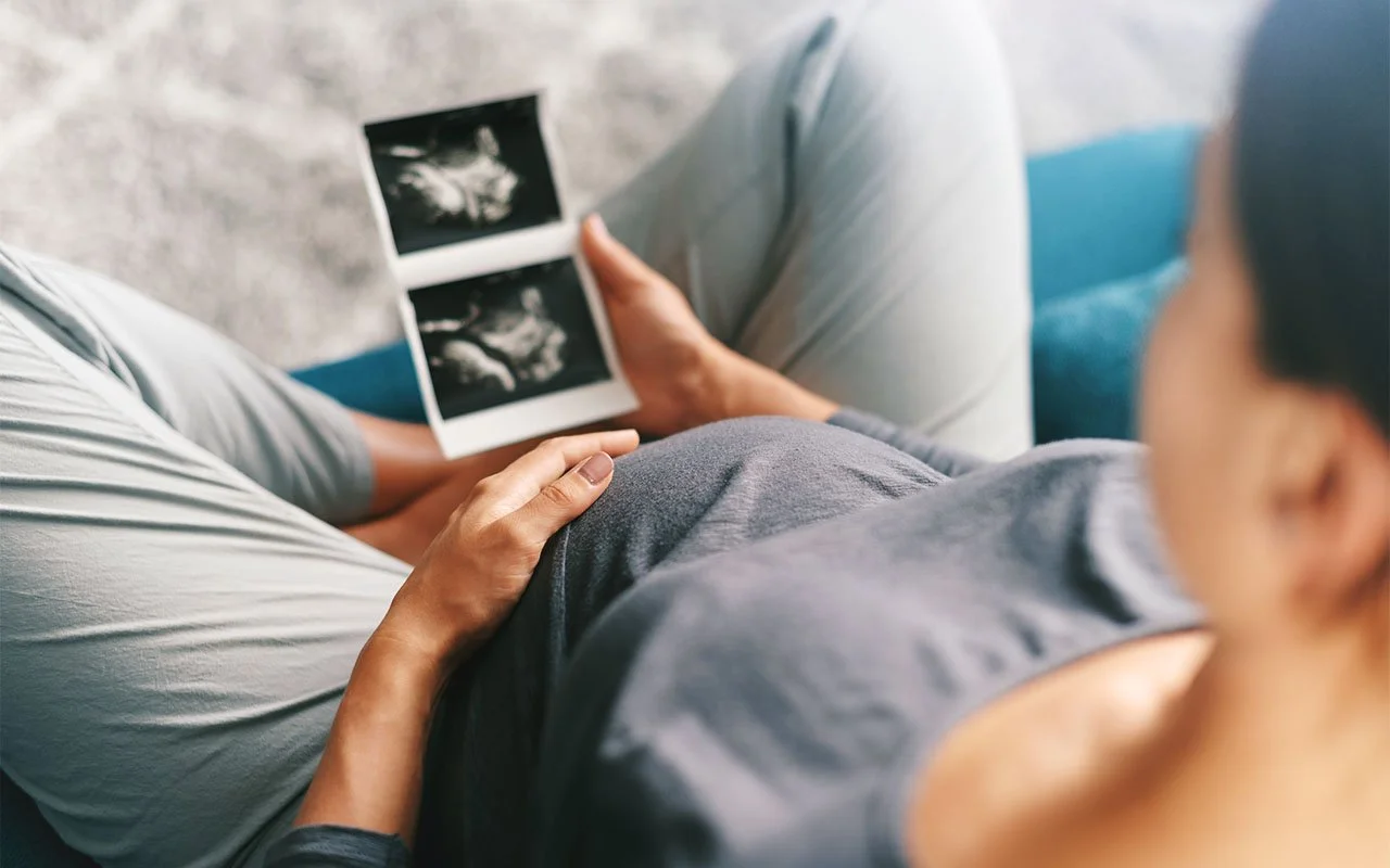 Pregnant Woman Looking At Ultrasound Scan Of Baby